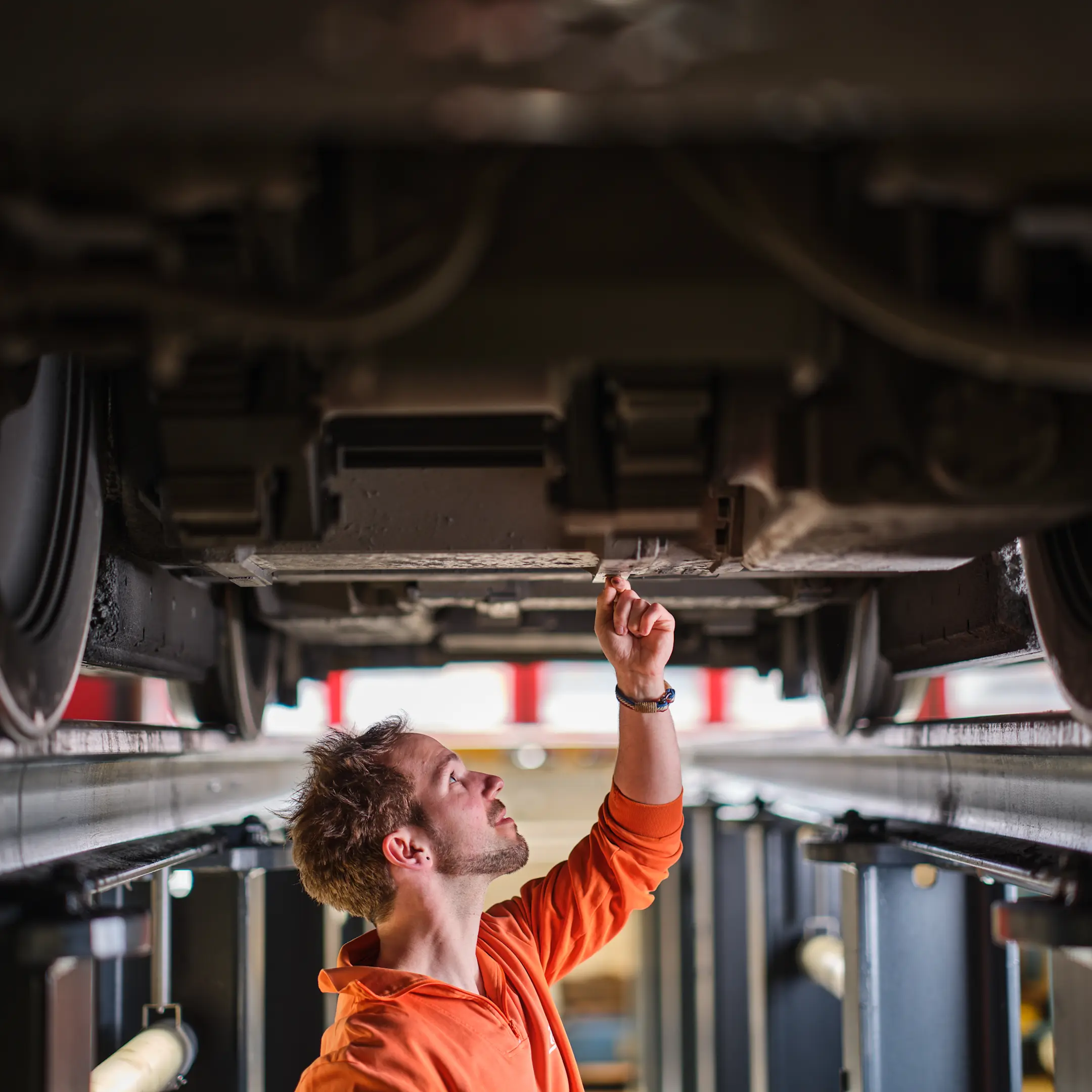 Ein Mitarbeiter der RhB kontrolliert die Unterseite des Zuges.