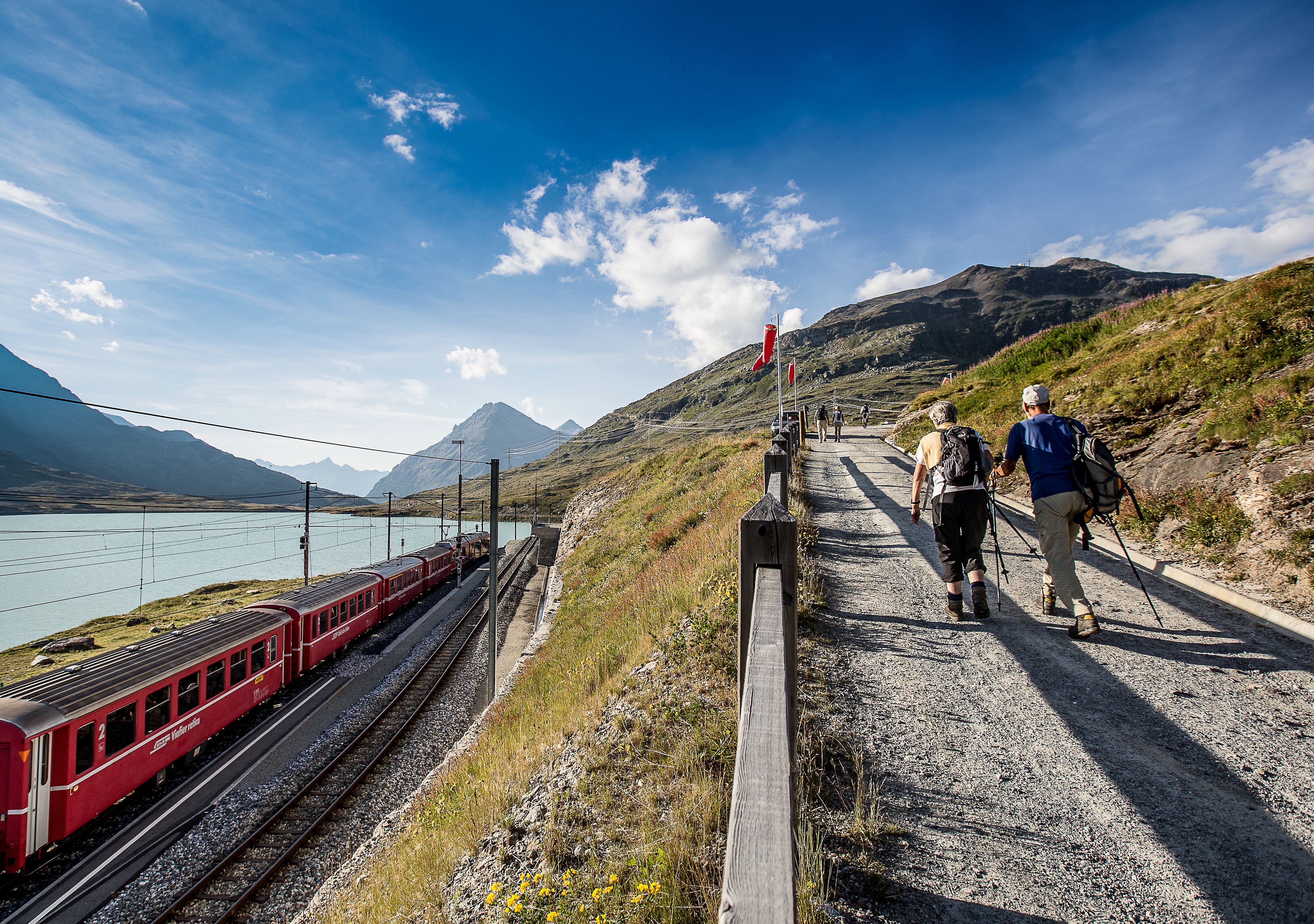 Zwei Personen wandern beim Lago Bianco oberhalb der Gleise.