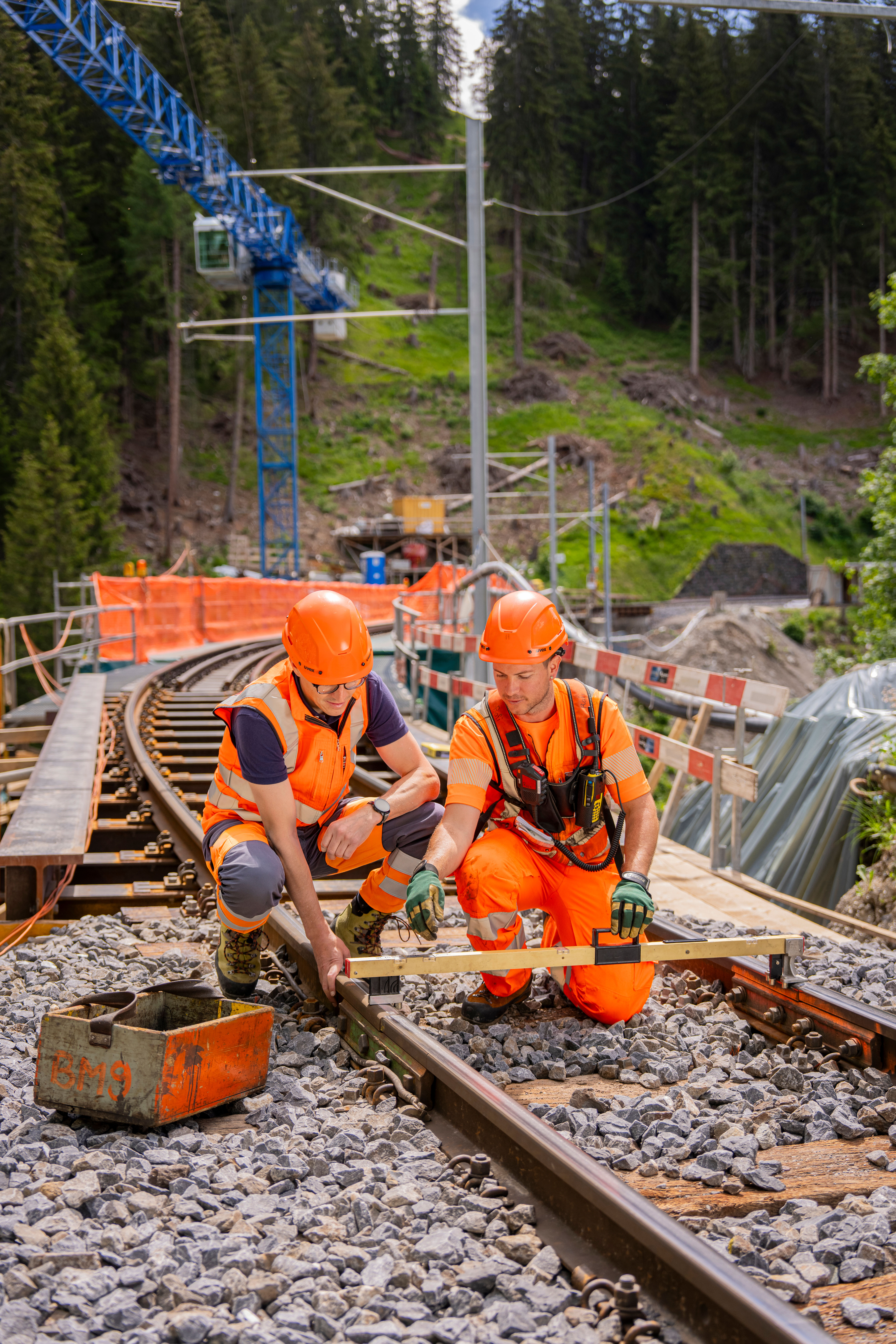 Ein Ingenieur und ein Gleisbauer auf einer Baustelle in Graubünden