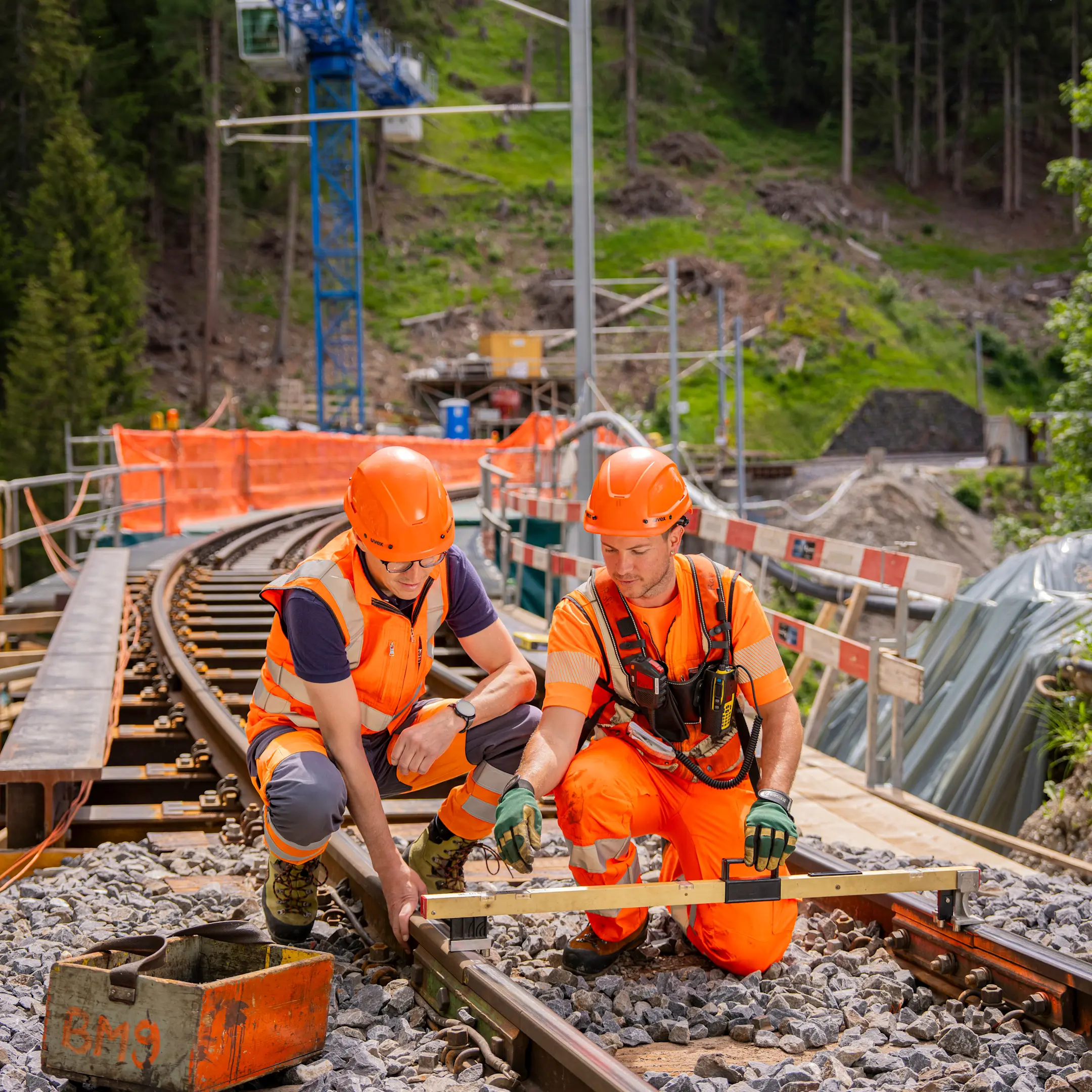 Ein Ingenieur und ein Gleisbauer auf einer Baustelle in Graubünden