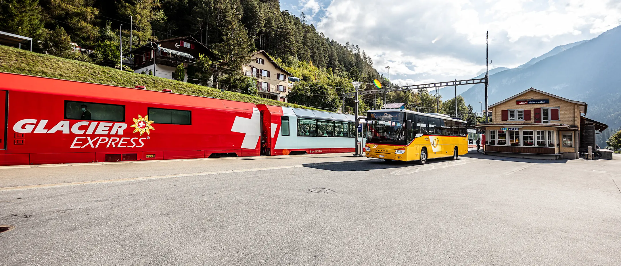 Glacier Express Panoramawagen und Postauto am Bahnhof Tiefencastel, Albulalinie