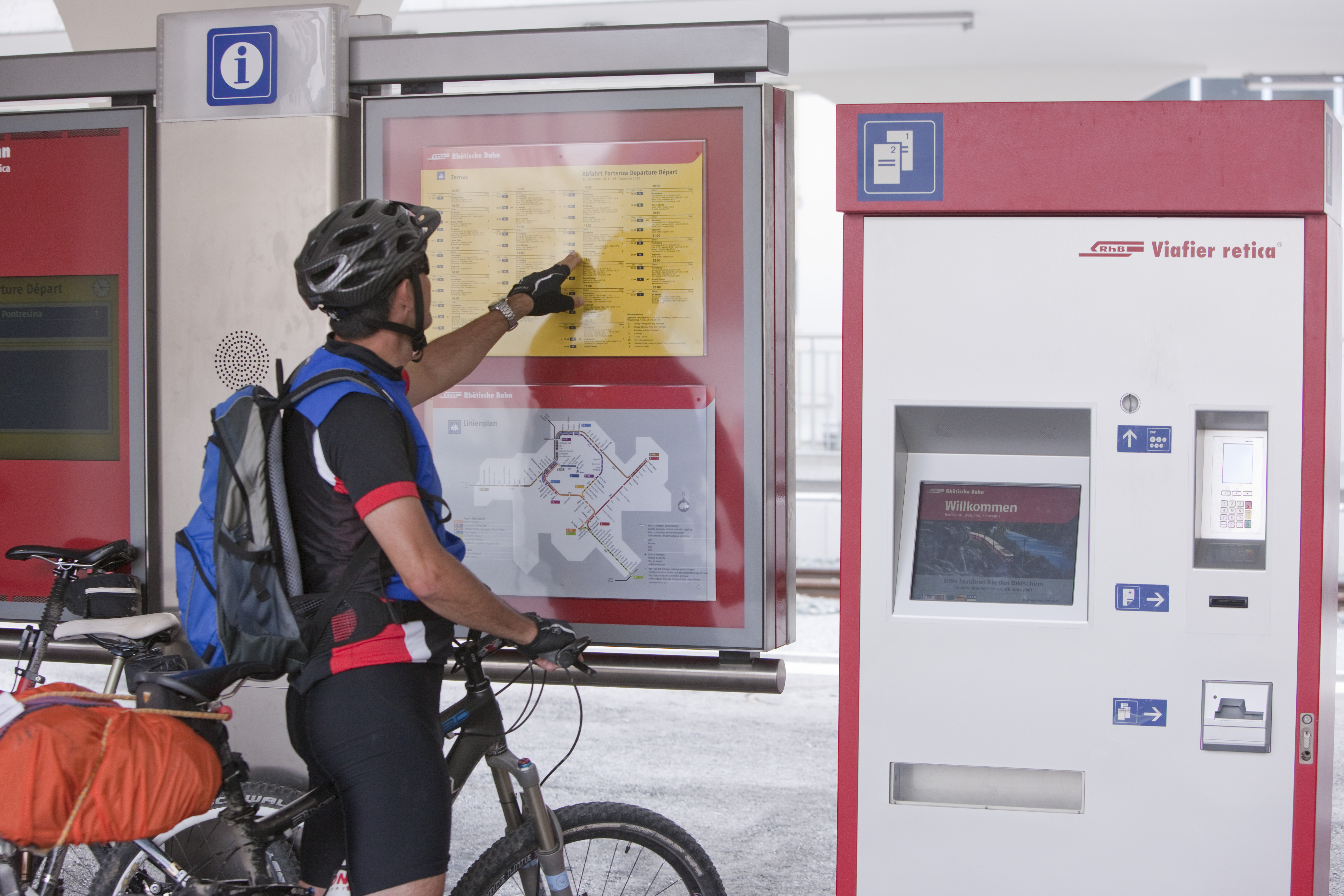 Un ciclista studia l’orario della Ferrovia retica.