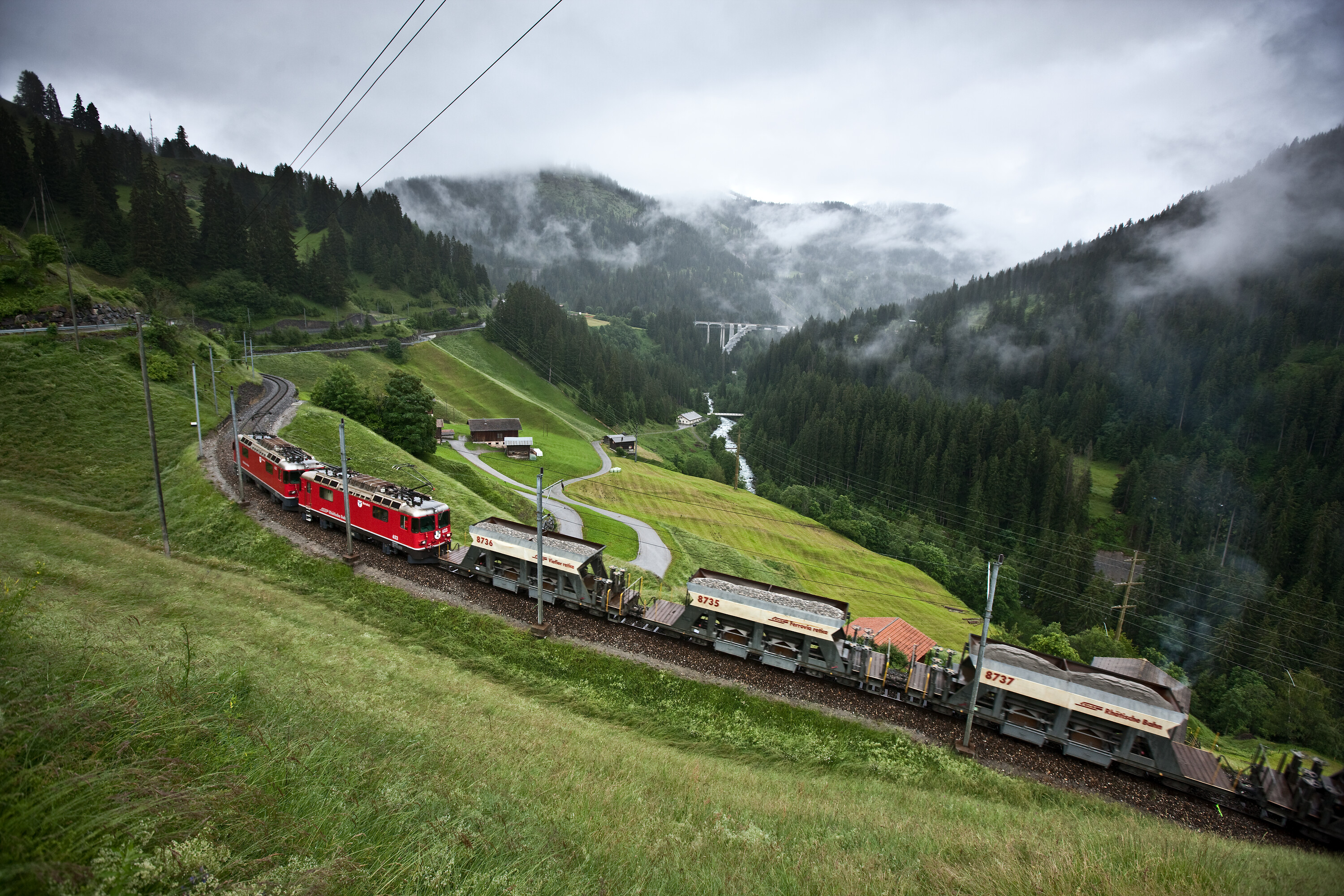 Drei Schüttgutwagen der Rhätischen Bahn auf der Schiene