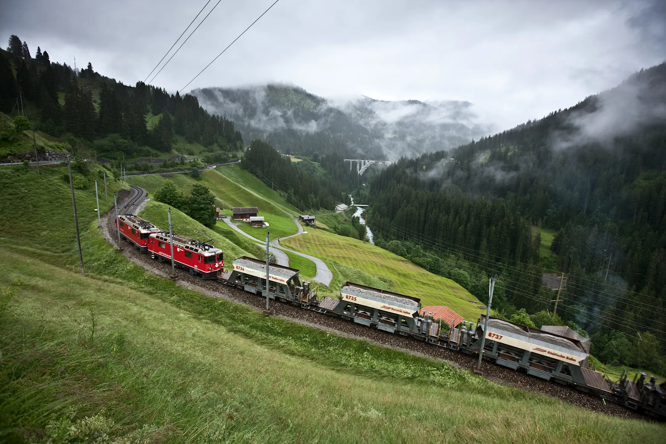 Drei Schüttgutwagen der Rhätischen Bahn auf der Schiene