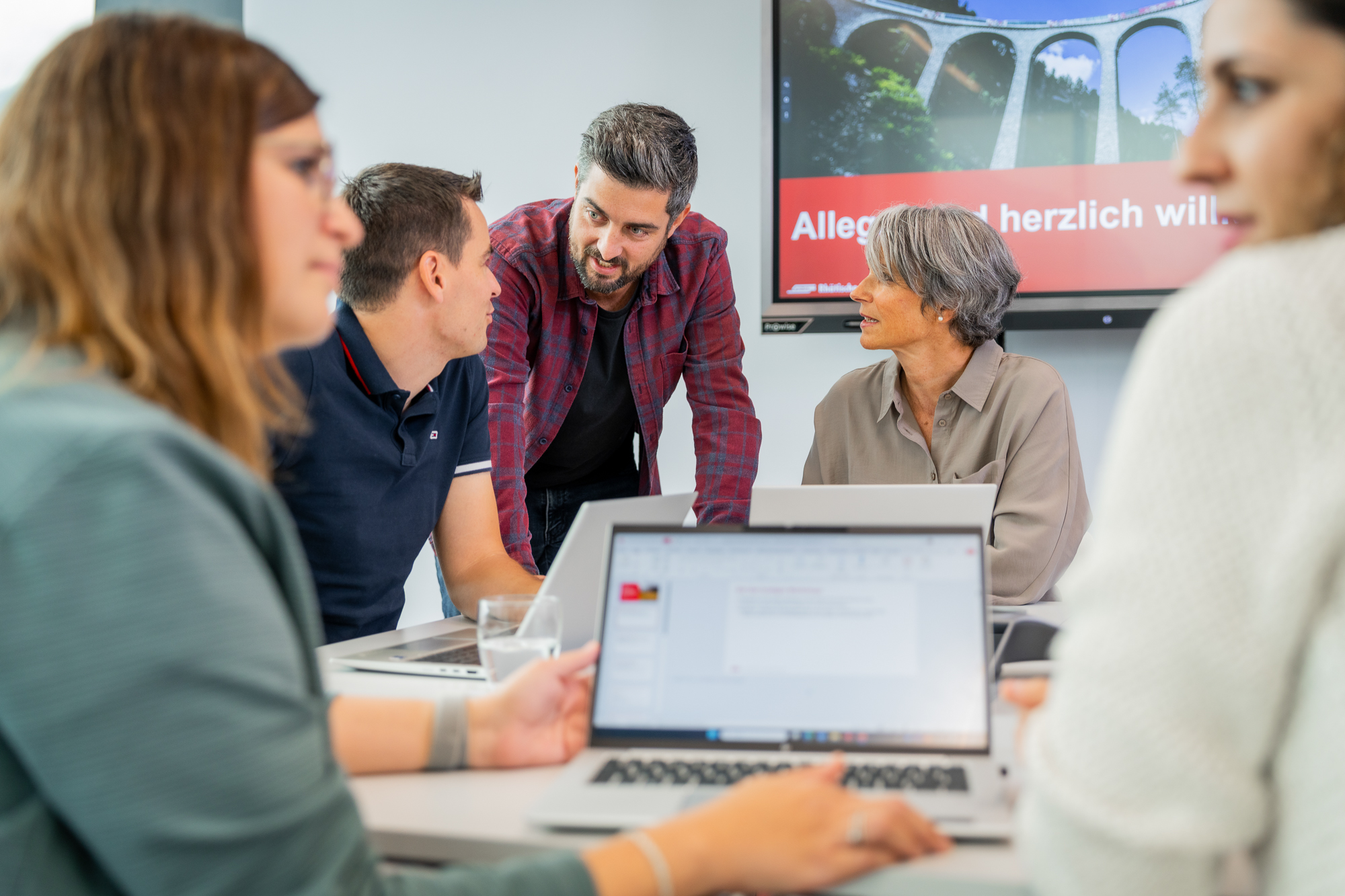 Mitarbeitende besprechen sich an einer Sitzung