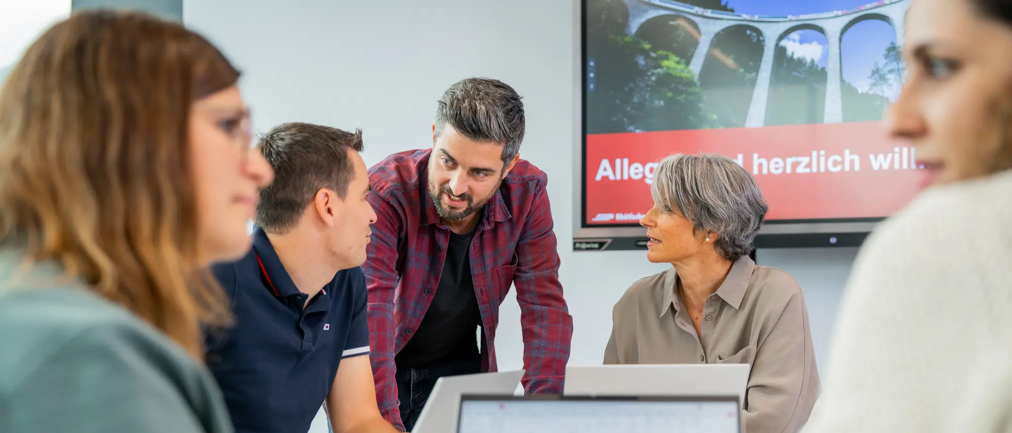 Mitarbeitende besprechen sich an einer Sitzung