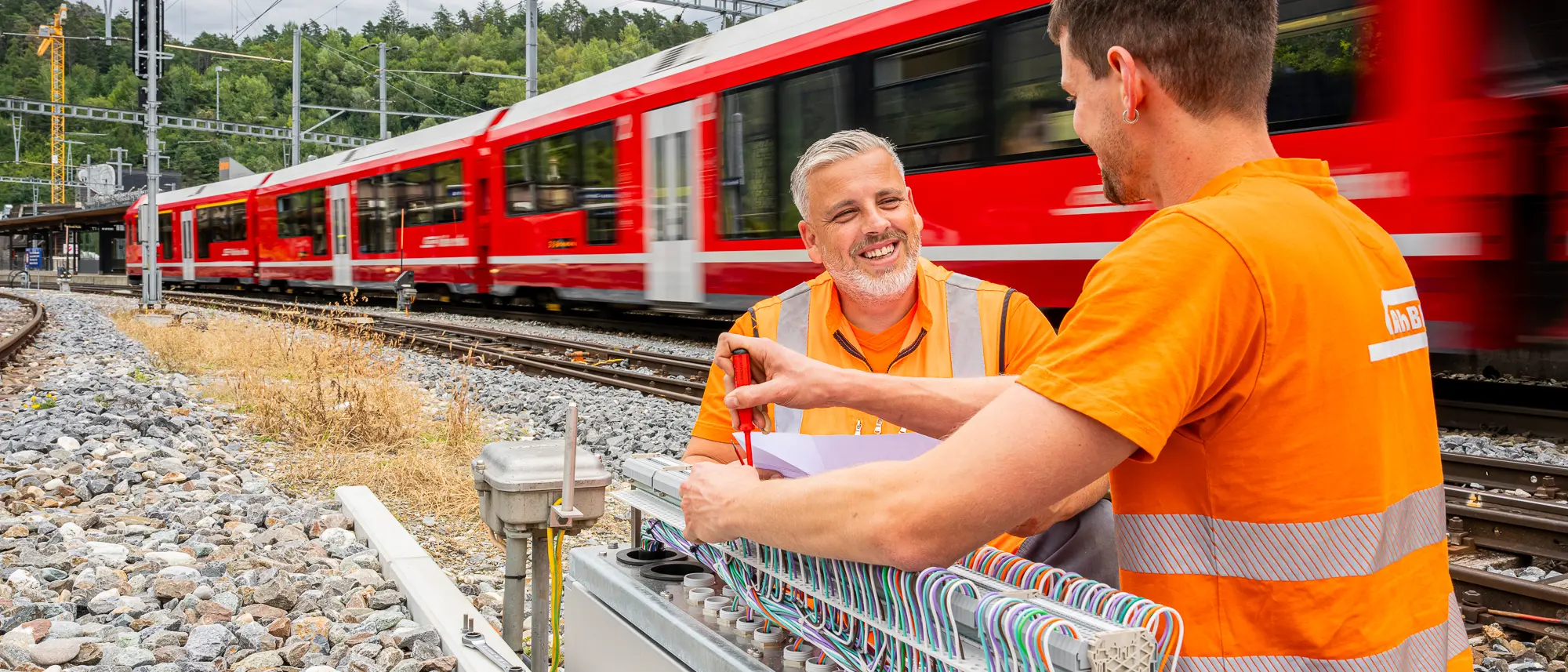 Zwei Elektroinstallateure bei der Arbeit am Gleis