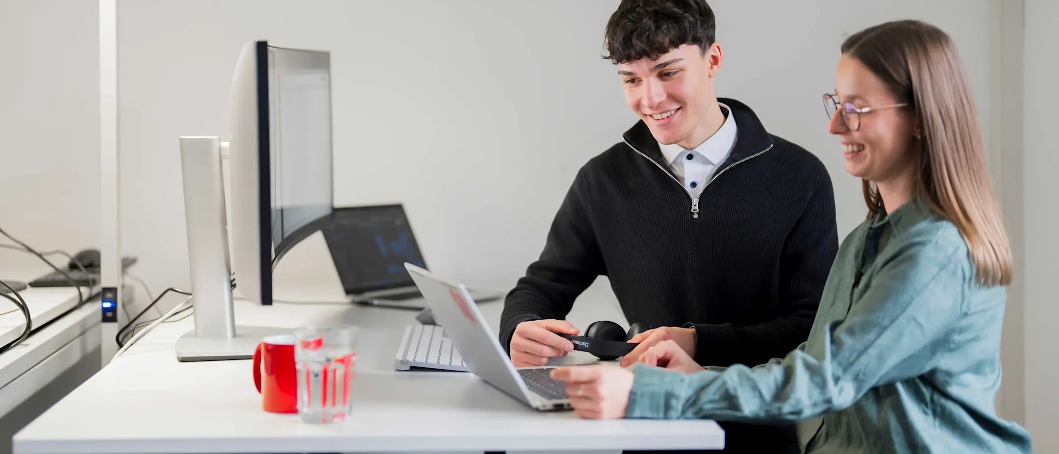 Ein Mitarbeiter und eine Mitarbeiterin besprechen etwas am Notebook