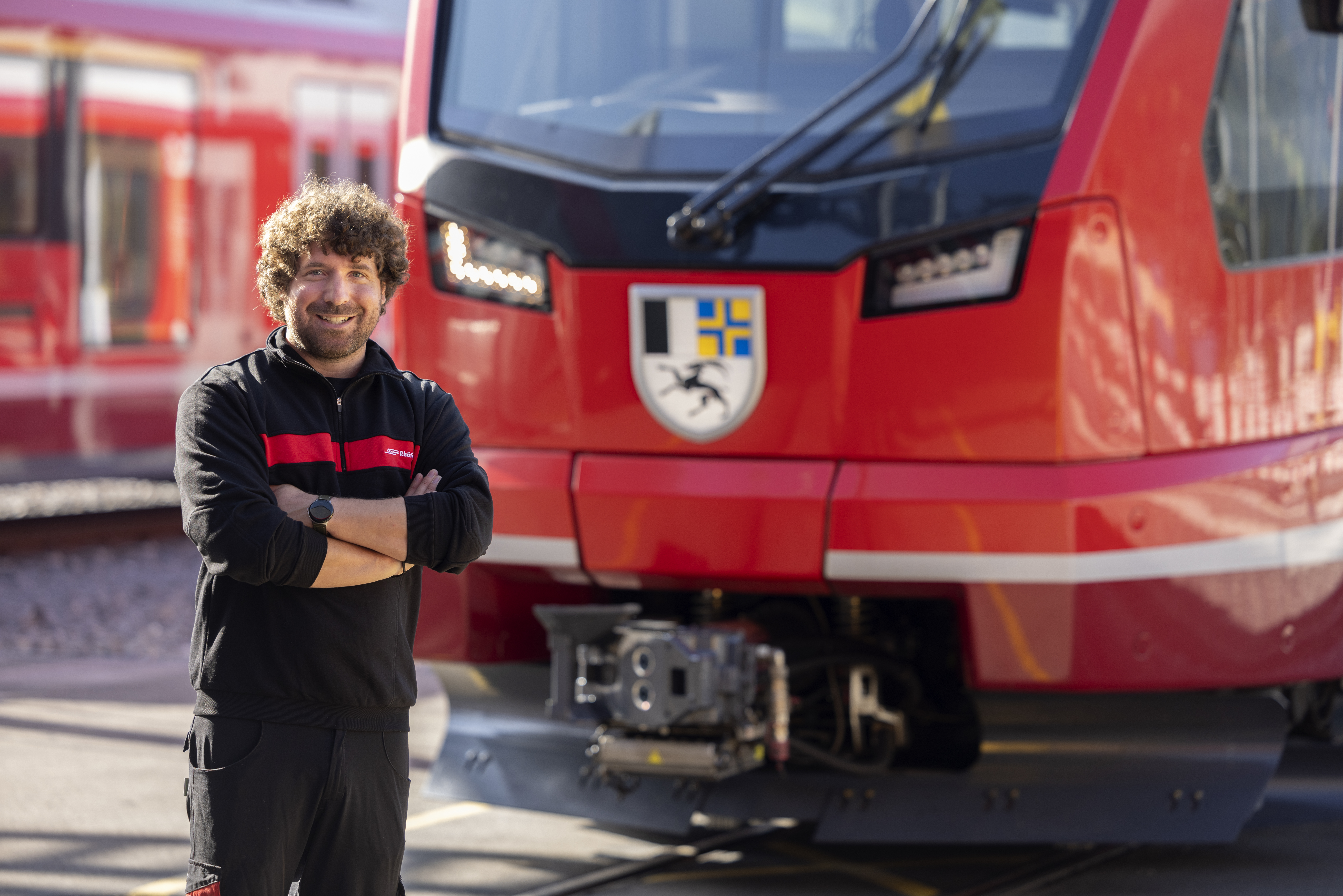 Der RhB-Lokführer Fabio Peng steht vor einer Lokomotive.