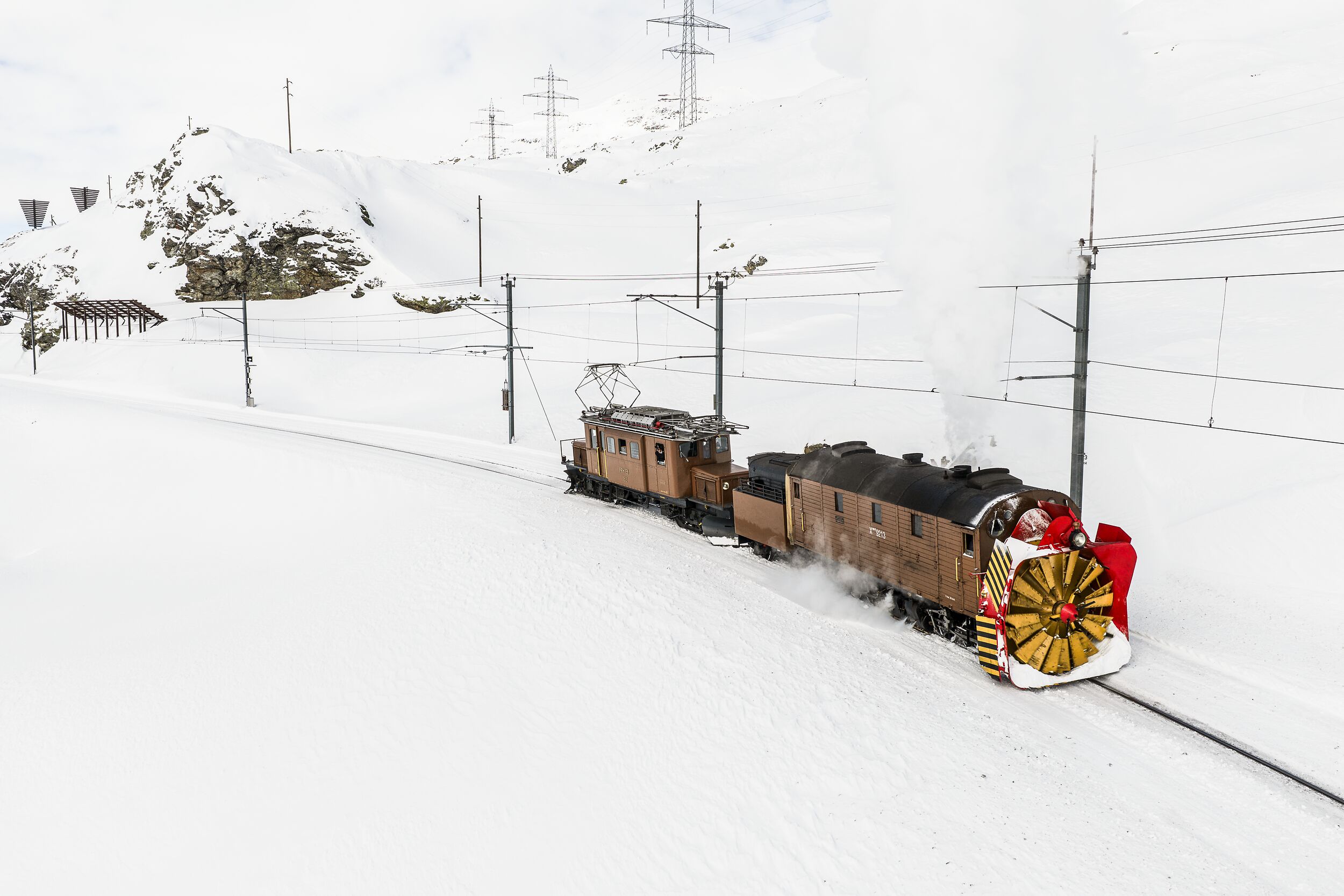 Dampfschneeschleuder der Rhätischen Bahn bei Ospizio Bernina – umgeben von staunenden Zuschauerinnen und Zuschauern.