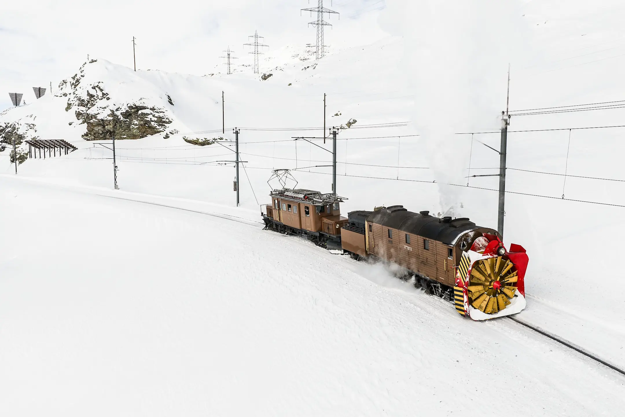 Dampfschneeschleuder der Rhätischen Bahn bei Ospizio Bernina – umgeben von staunenden Zuschauerinnen und Zuschauern.