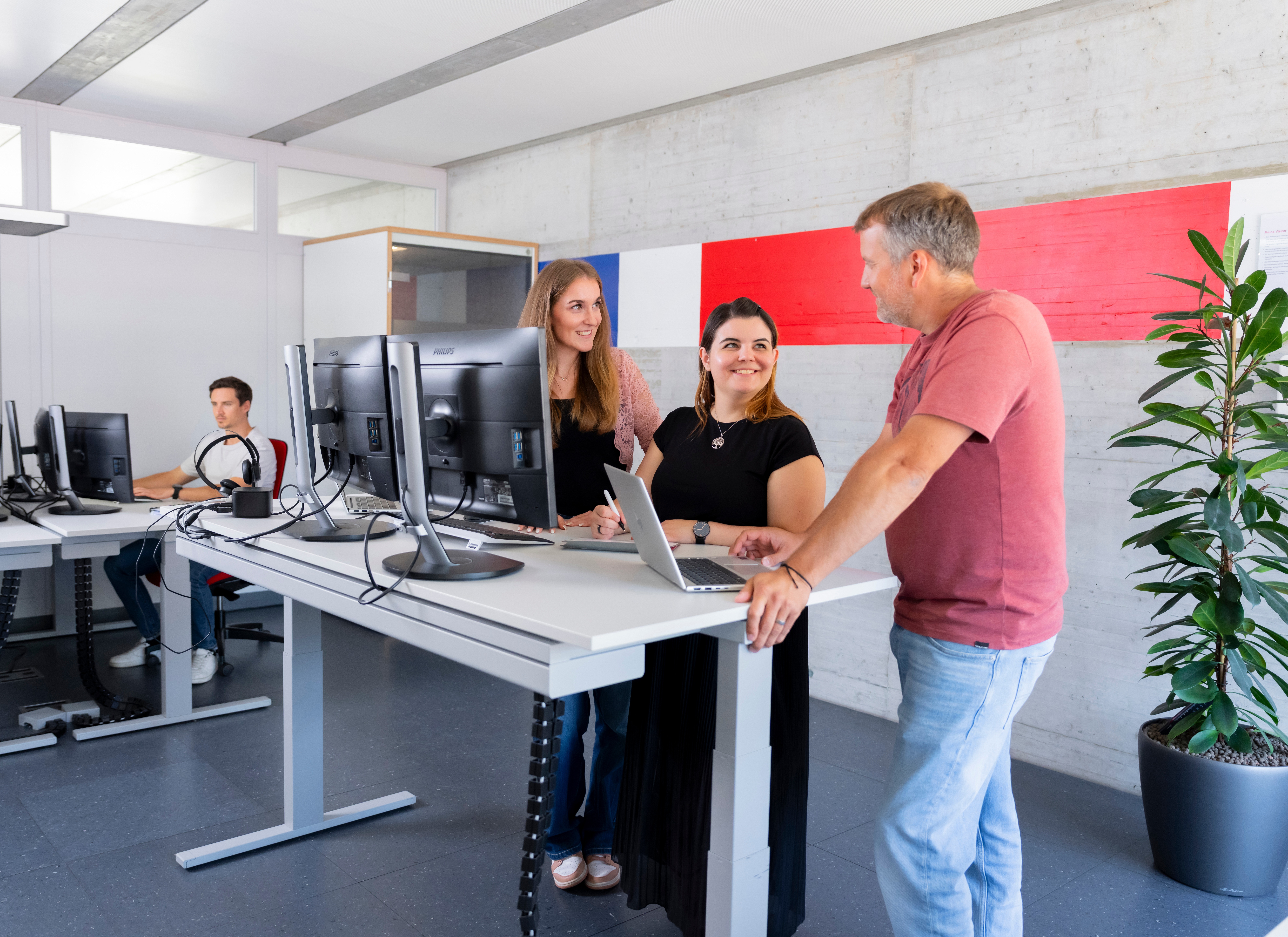 Three travel consultants from Railservice are working at a desk.