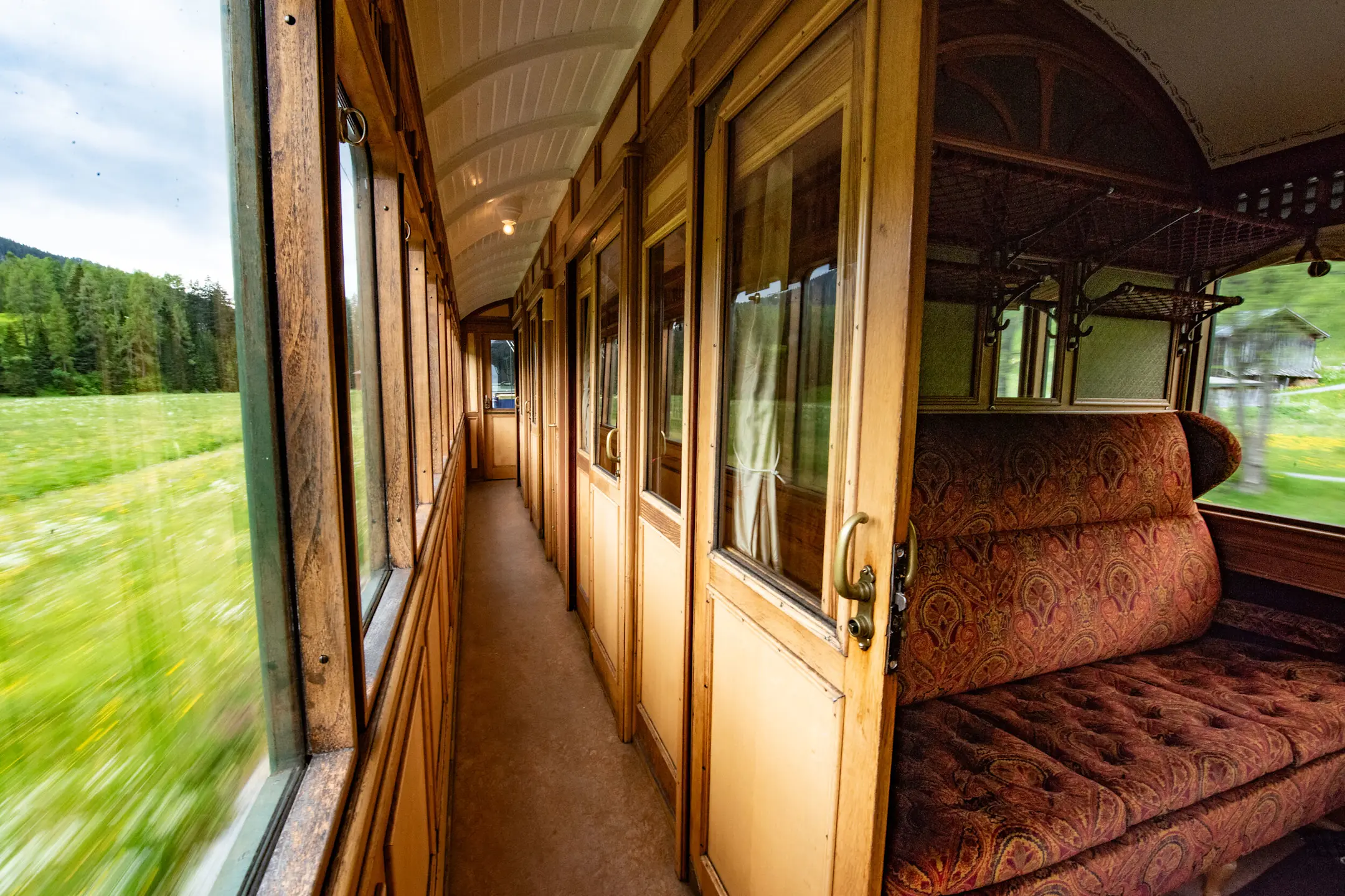 Innenansicht vom historischen 1. Klasse Wagen der RhB mit seinen gepolsterten Bänken.