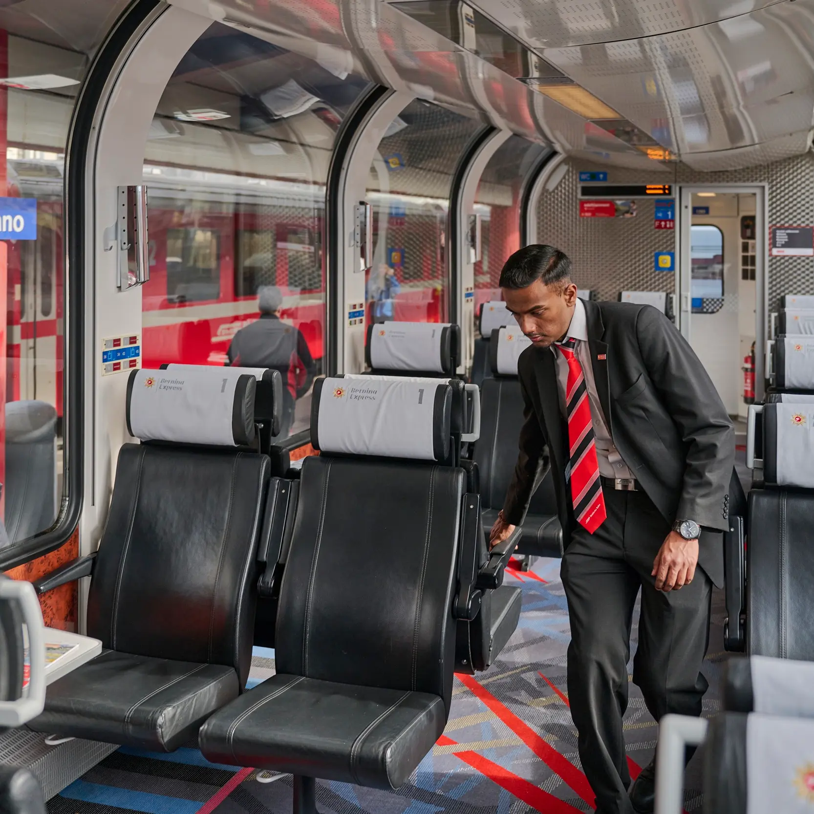 Ein Zugbegleiter der RhB richtet die Armlehnen im Bernina Express.