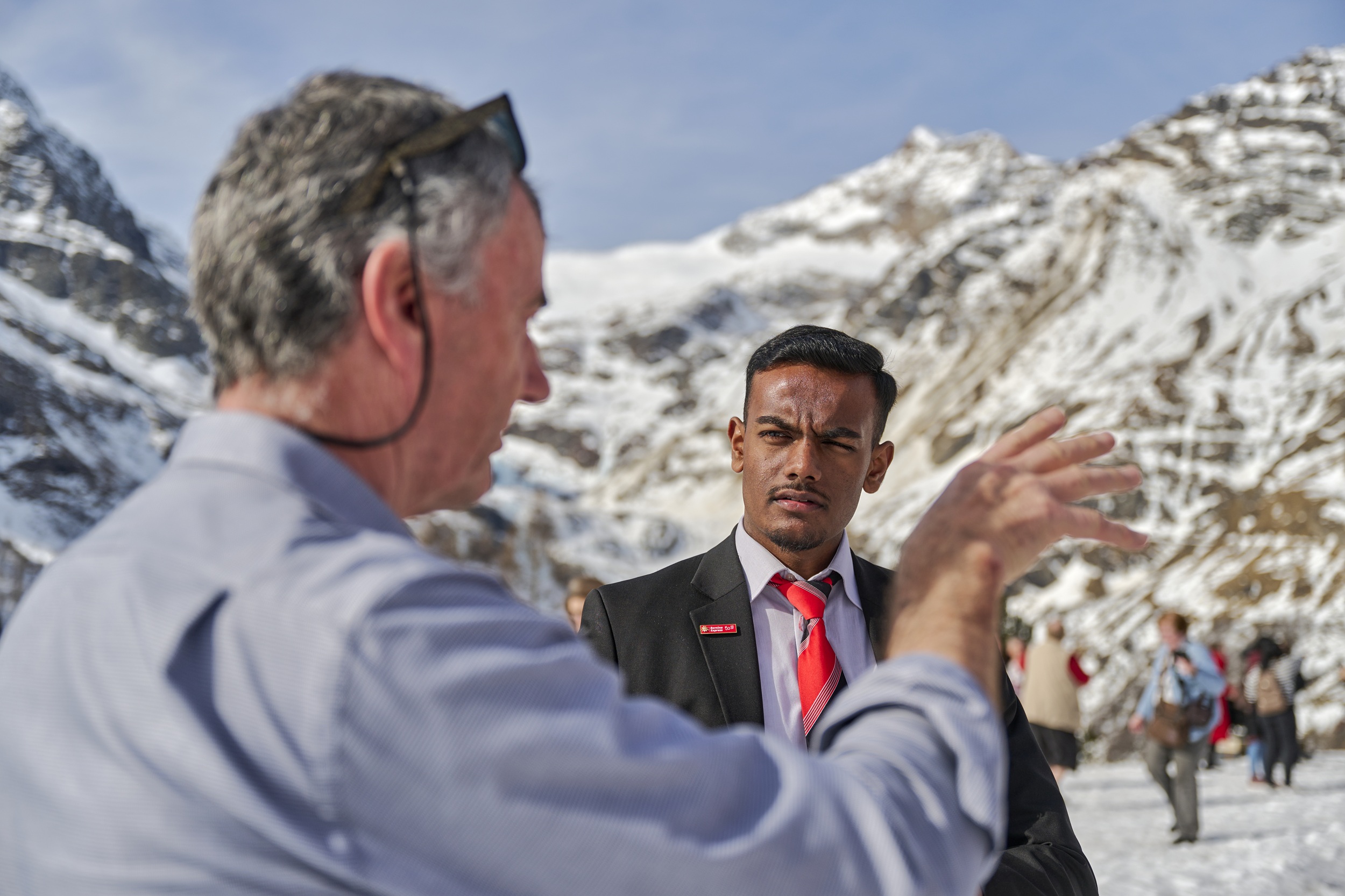 Ein Zugbegleiter der Rhätischen Bahn redet mit einem Gast. 