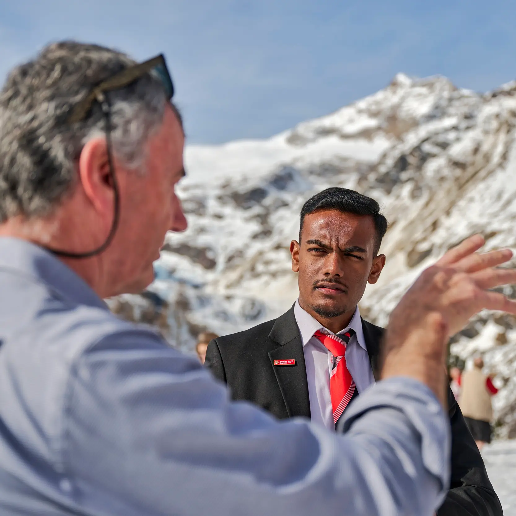 Ein Zugbegleiter der Rhätischen Bahn redet mit einem Gast.