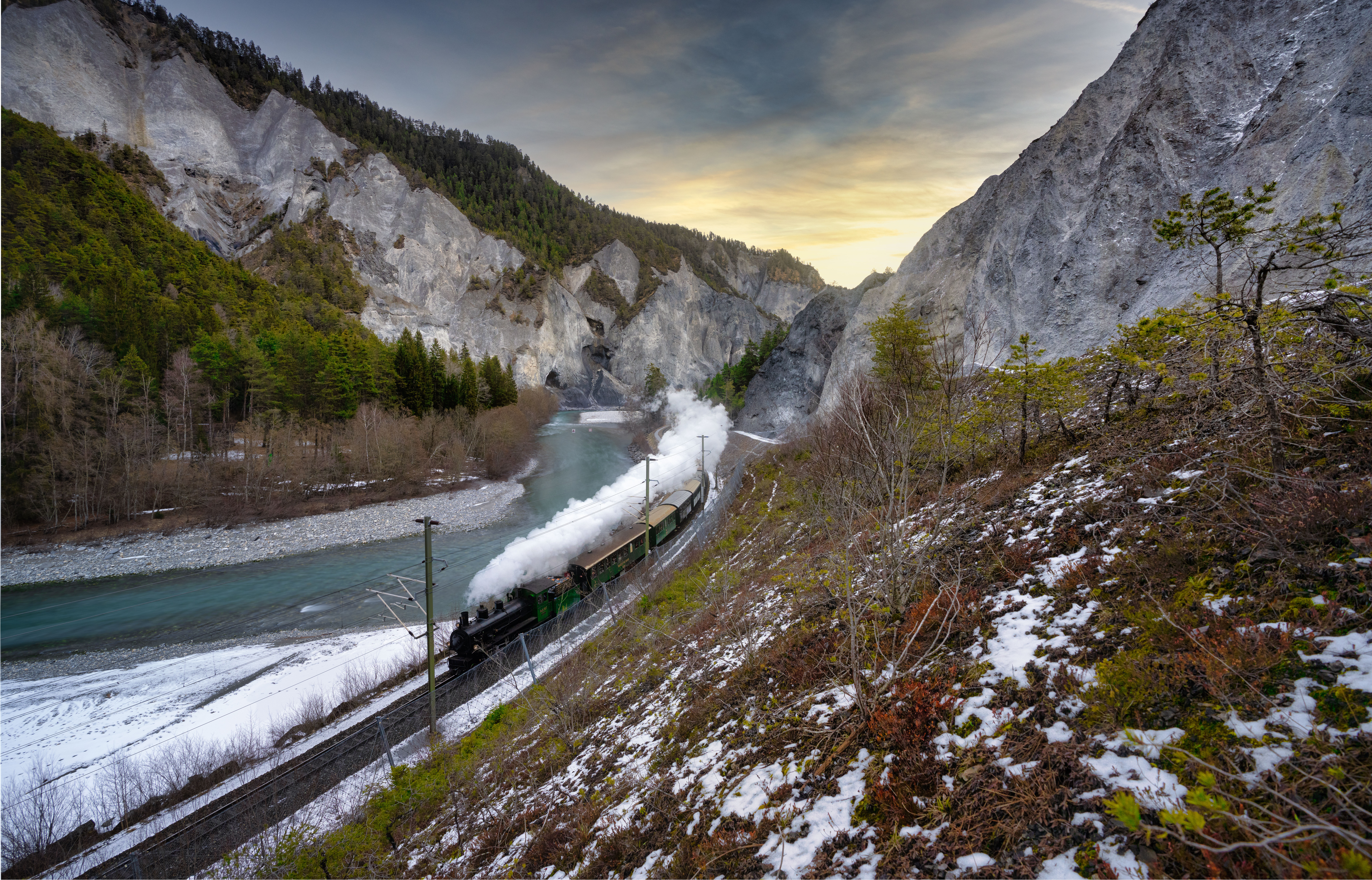 An RhB steam train travels through the wintry landscape.
