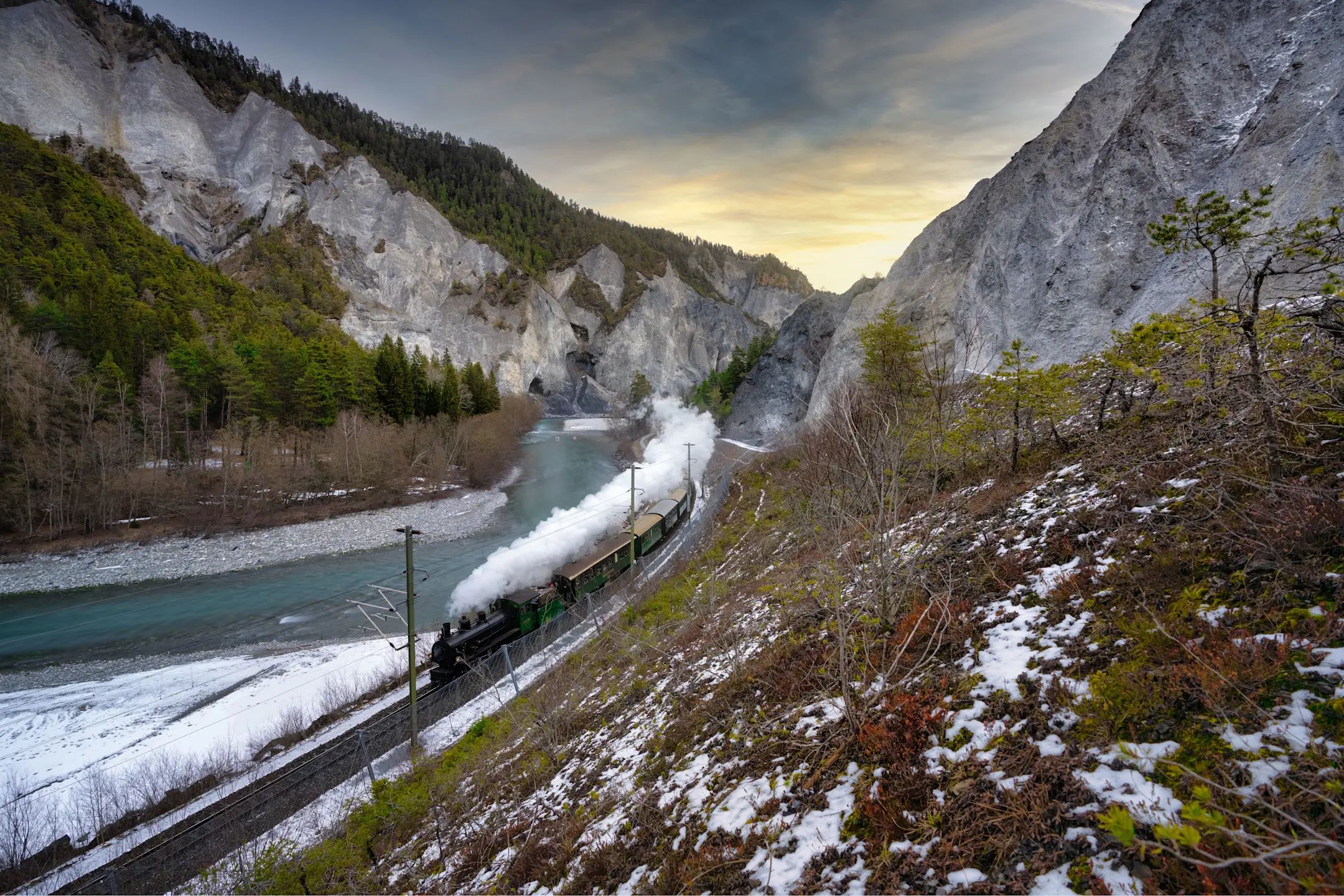 Ein Dampfzug der RhB fährt durch die winterliche Landschaft.