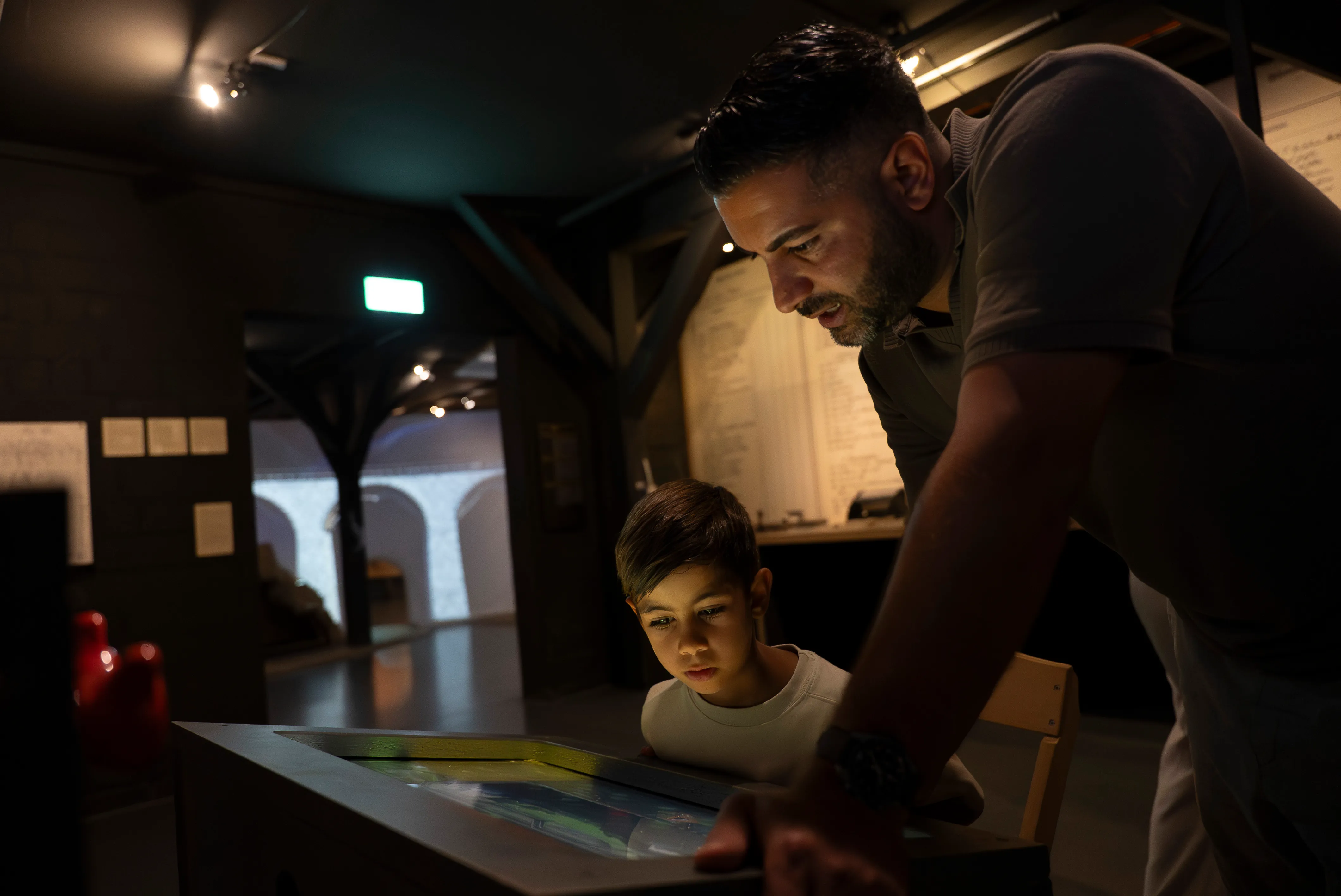 Vater und Sohn betrachten Screen im Bahnmuseum Albula. 