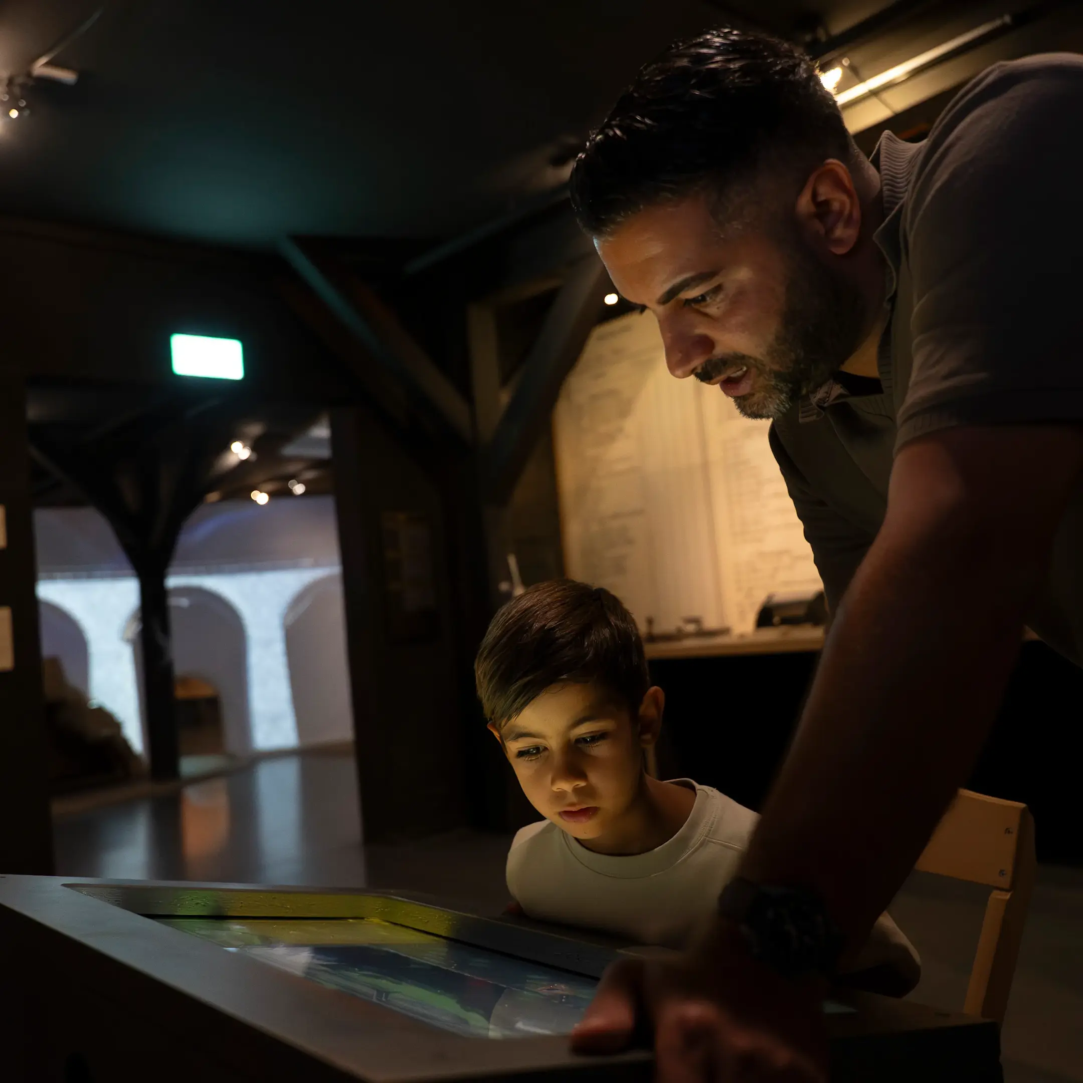 Vater und Sohn betrachten Screen im Bahnmuseum Albula.