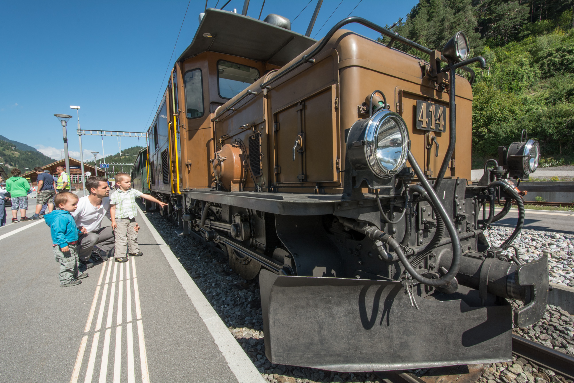 Kinder betrachten das RhB-Krokodil an einem Bahnhof auf der Albulalinie.