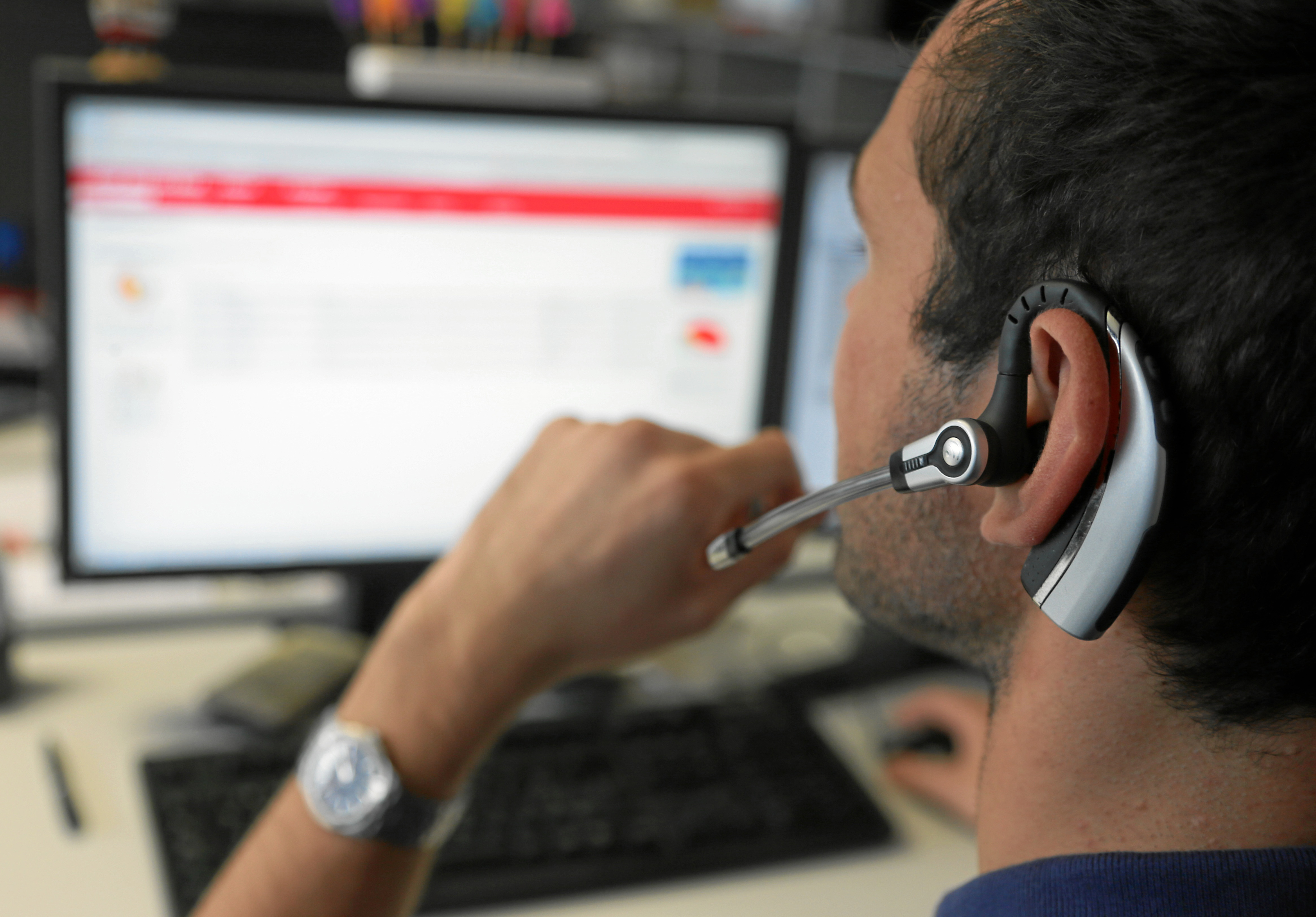 Ein Informatiker der Rhätischen Bahn hat ein Headset auf und redet