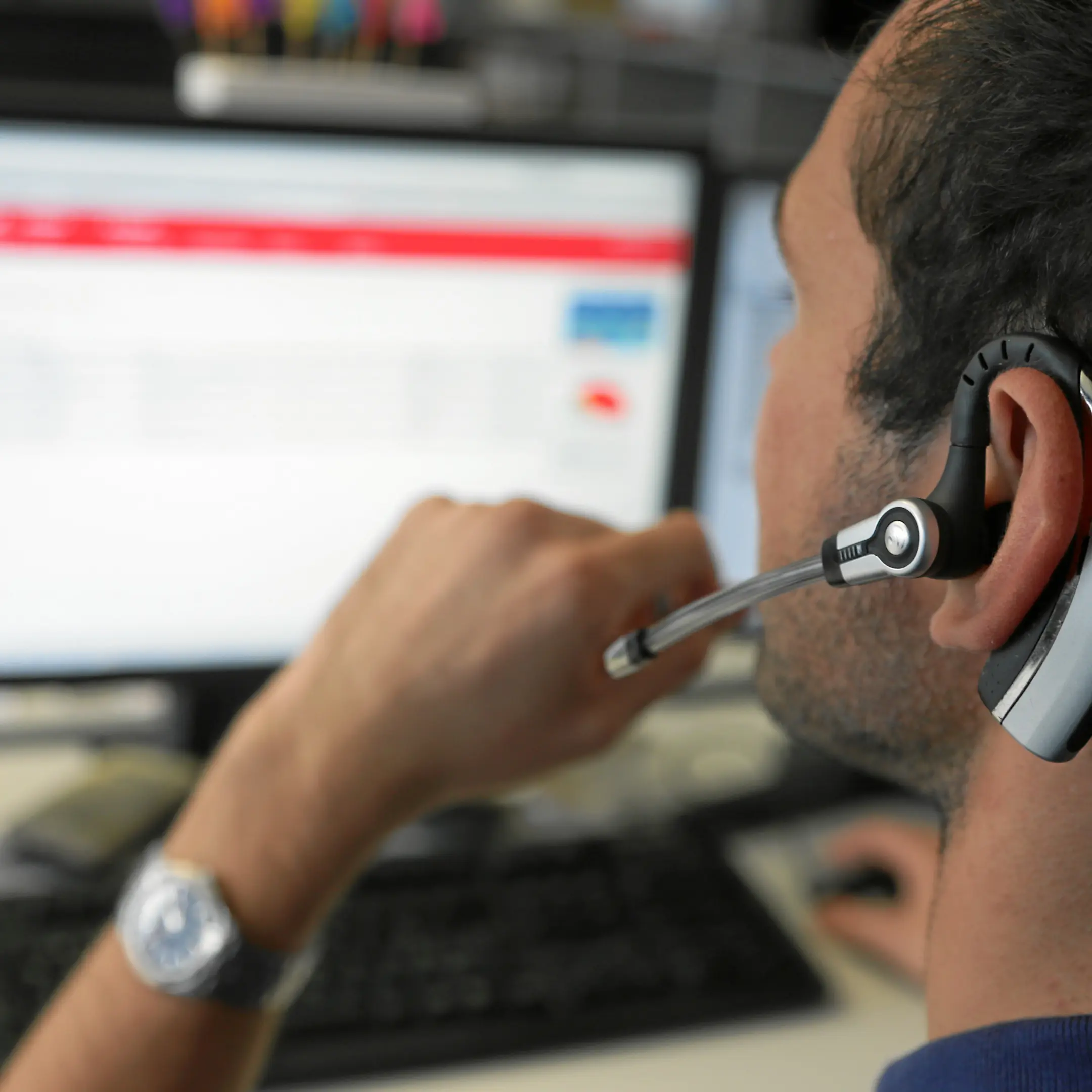 Ein Informatiker der Rhätischen Bahn hat ein Headset auf und redet