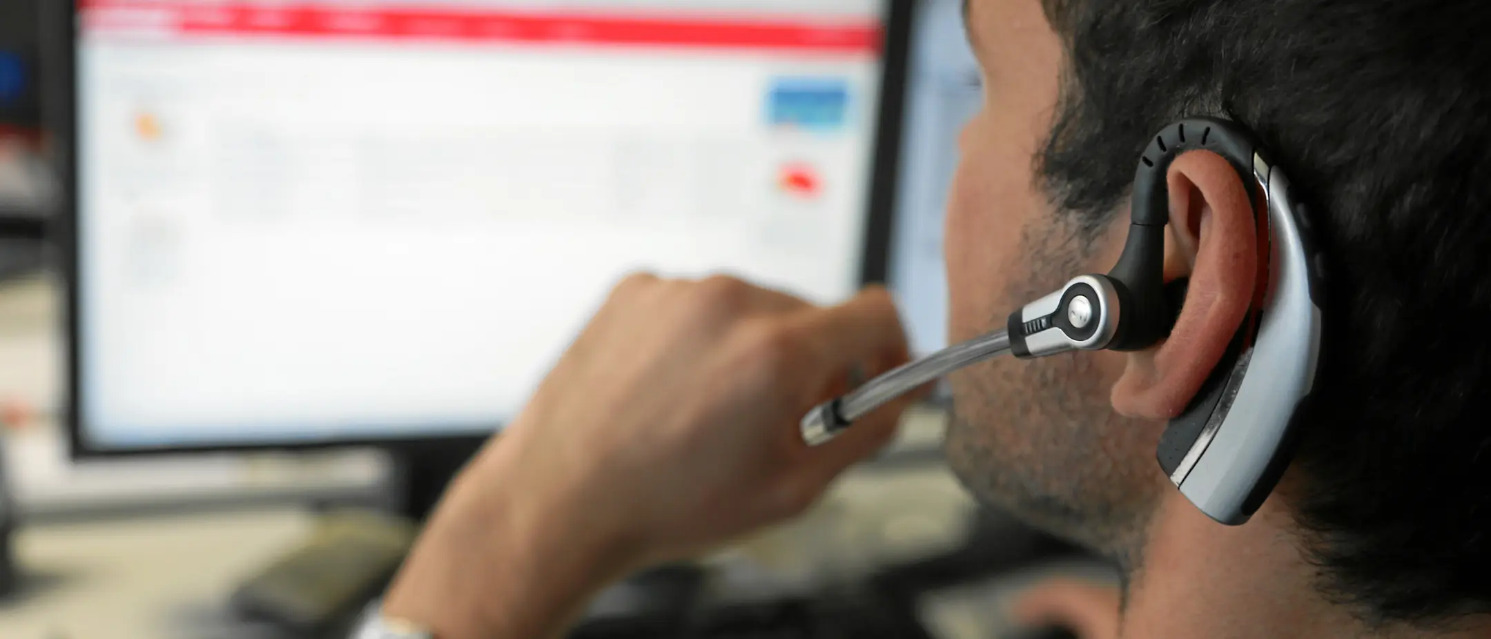 Ein Informatiker der Rhätischen Bahn hat ein Headset auf und redet