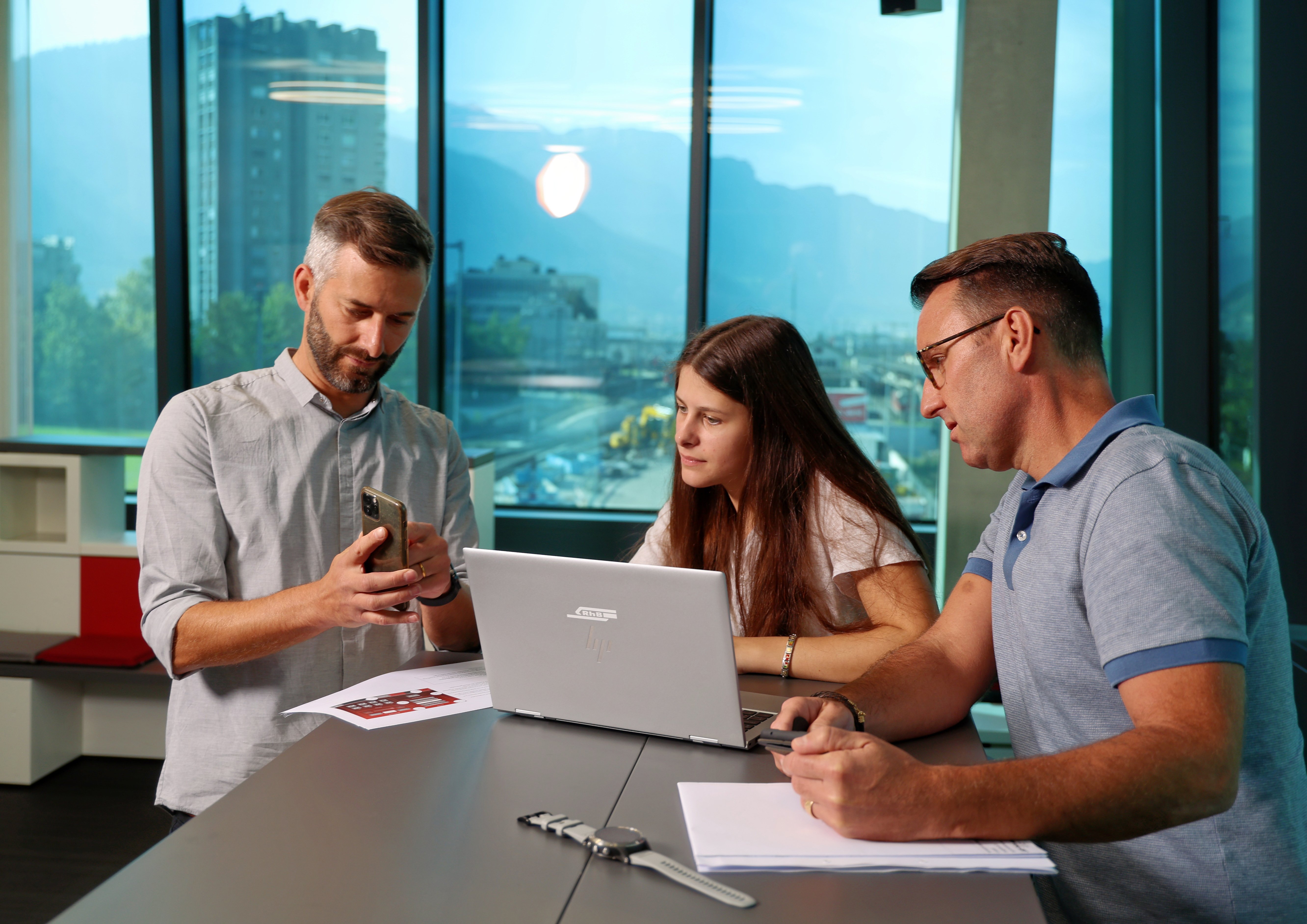 Employees explain an application on their mobile phones.