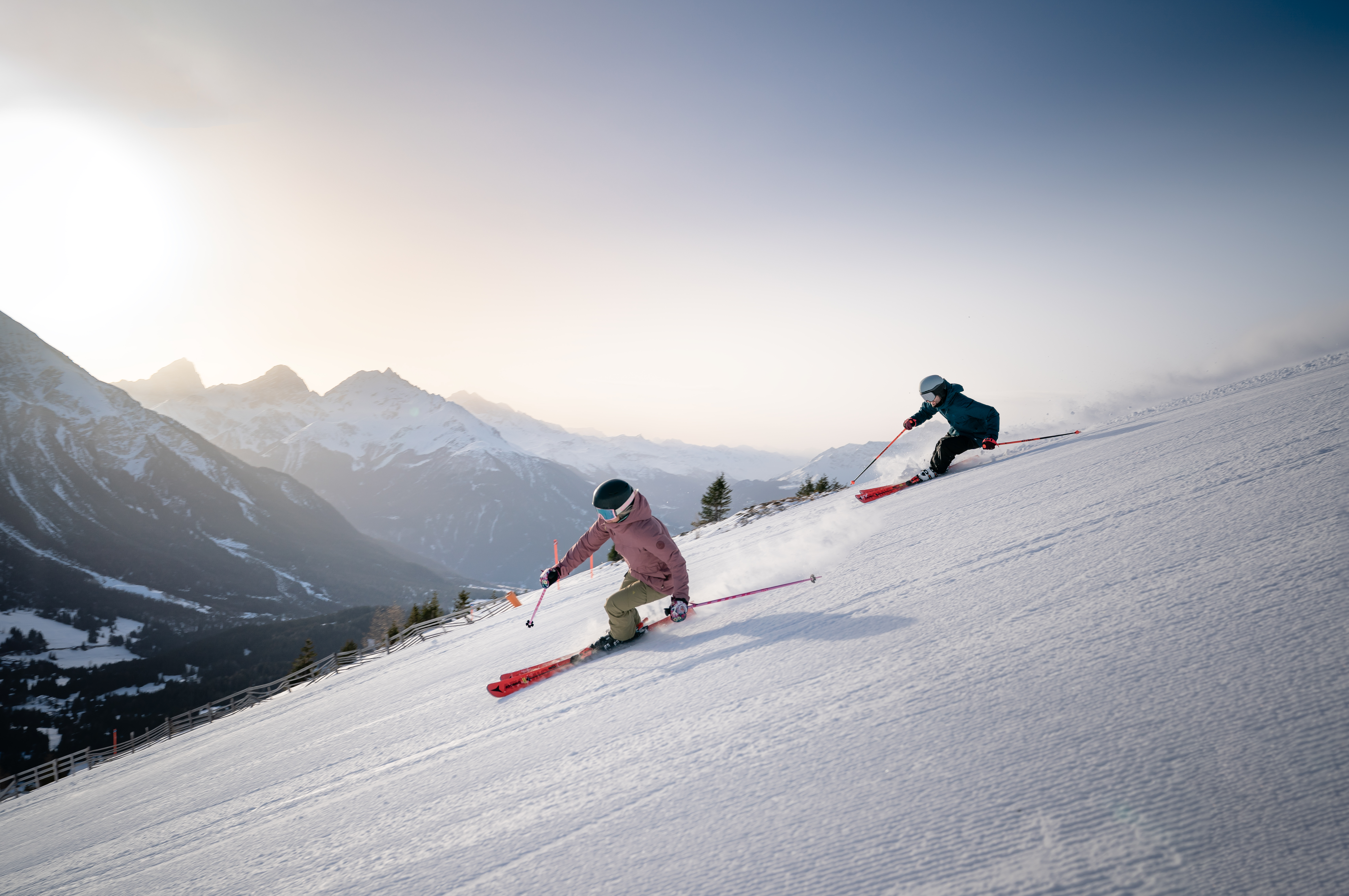 Skifahrer fahren im Skigebiet Arosa Lenzerheide rasant die Piste hinunter. 