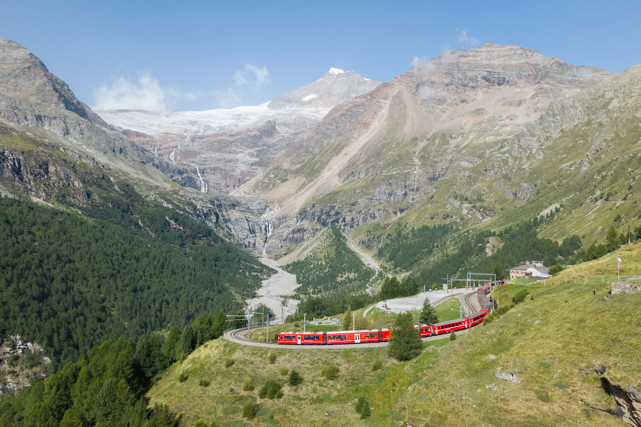 Ein Regionalzug der RhB fährt bei der Alp Grüm. Im Hintergrund ist der Morteratschgletscher zu sehen.