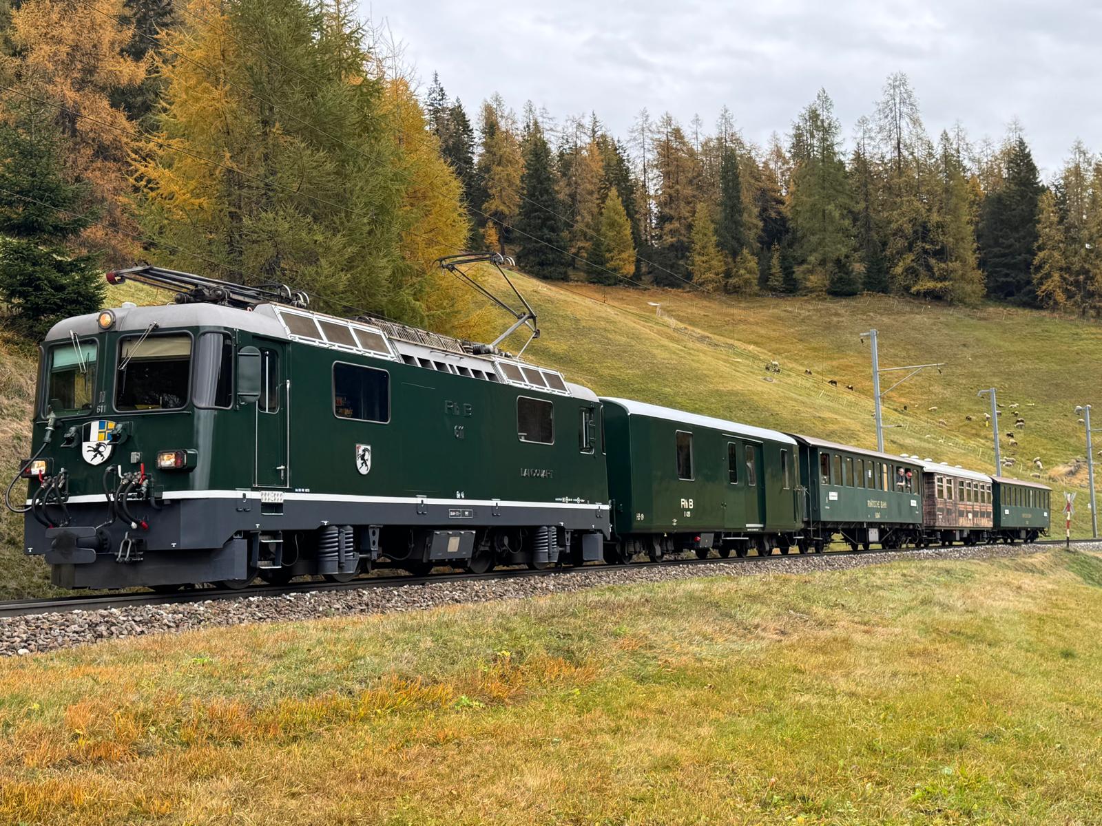 Die grünen Lok Ge 4/4 II 611 «Landquart» fährt durch die herbstliche Bündner Landschaft. 