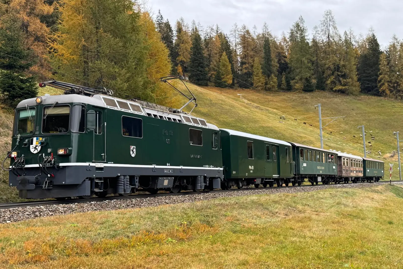 Die grünen Lok Ge 4/4 II 611 «Landquart» fährt durch die herbstliche Bündner Landschaft.