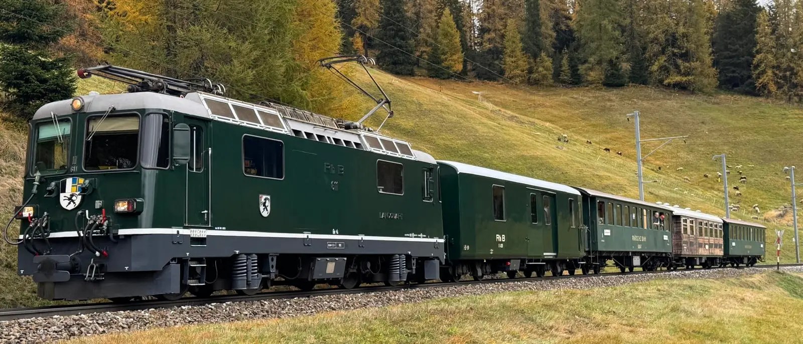 Die grünen Lok Ge 4/4 II 611 «Landquart» fährt durch die herbstliche Bündner Landschaft.