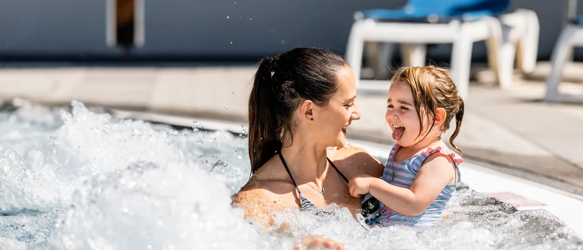 Blick auf das moderne Hallenbad Eau-là-là in Davos mit Besuchern im Wellness- und Badebereich.