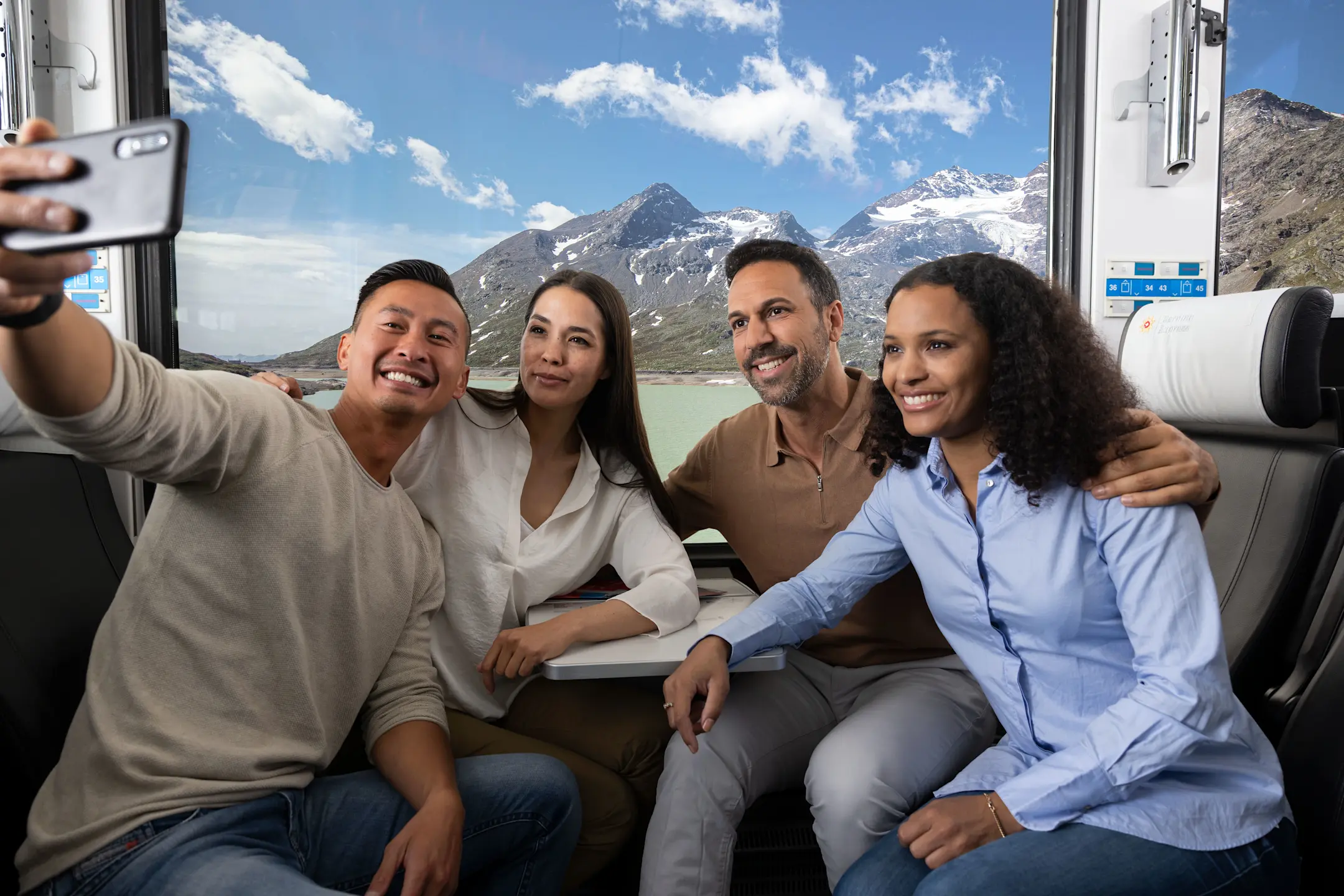 Vier Fahrgäste machen ein Selfie im Bernina Express.