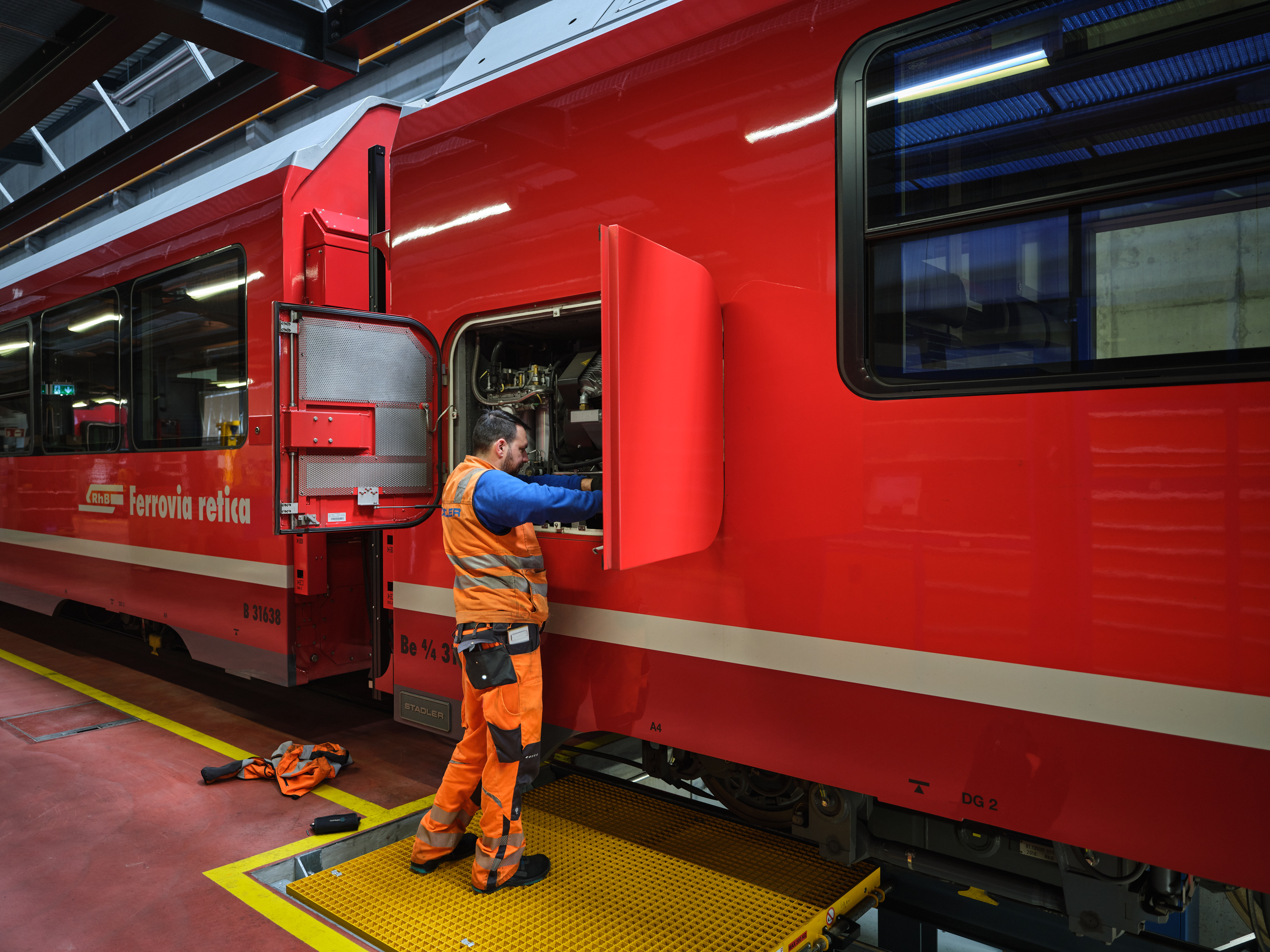 Ein Mitarbeiter der RhB führt Kontrollen am Capricorn Triebzug durch. 