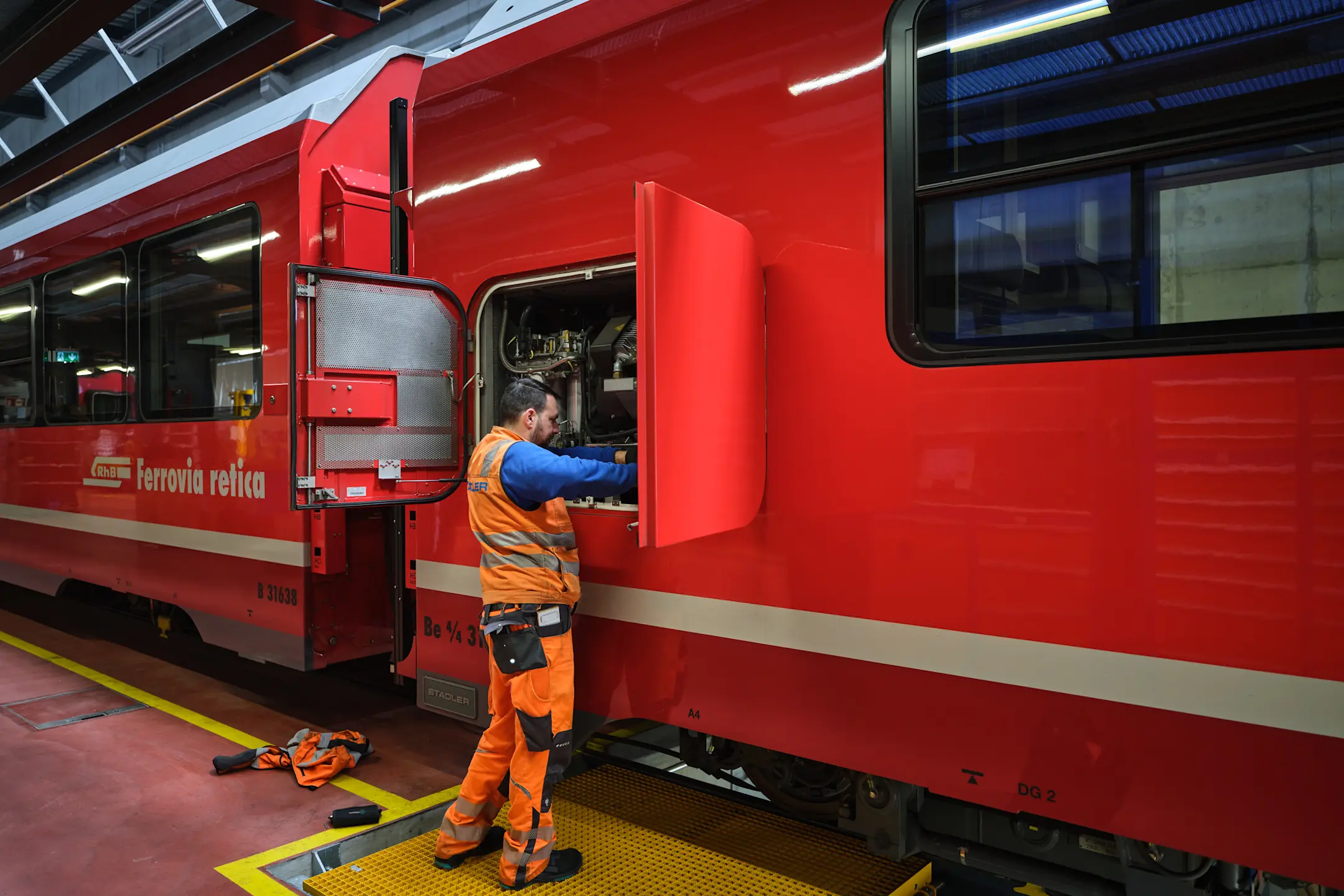 Ein Mitarbeiter der RhB führt Kontrollen am Capricorn Triebzug durch.