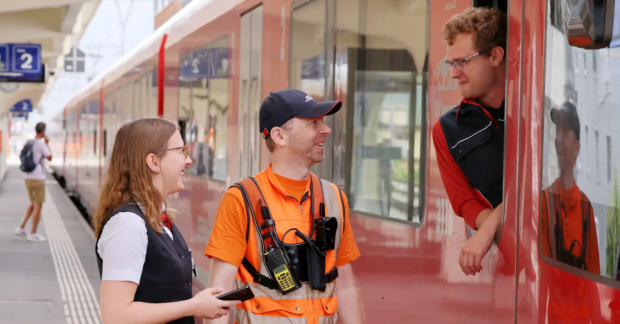 Drei Mitarbeitende der Rhätischen Bahn unterhalten sich an einem Zug