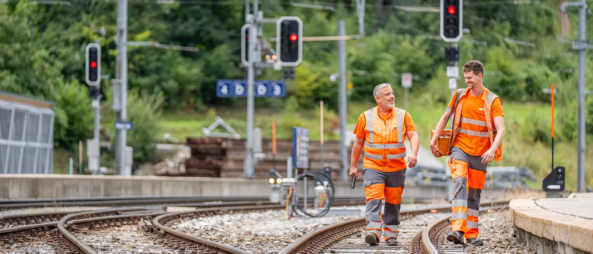 Zwei Elektroinstallateure am Laufen am Bahnhof Bonaduz