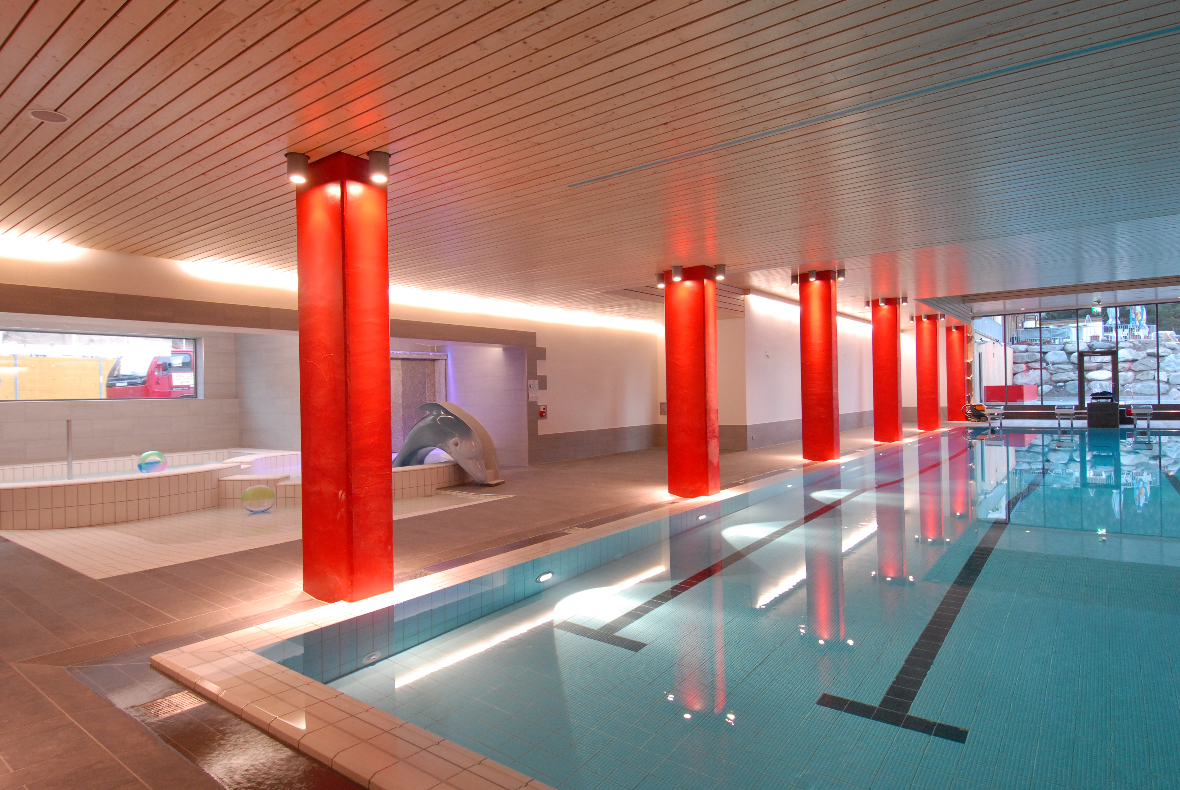 Innenpool des Familienbad Zernez: Neben einem Schwimmbecken mit eigezeichneten Bahnen gibt es ein Kinderbecken mit Rutsche.