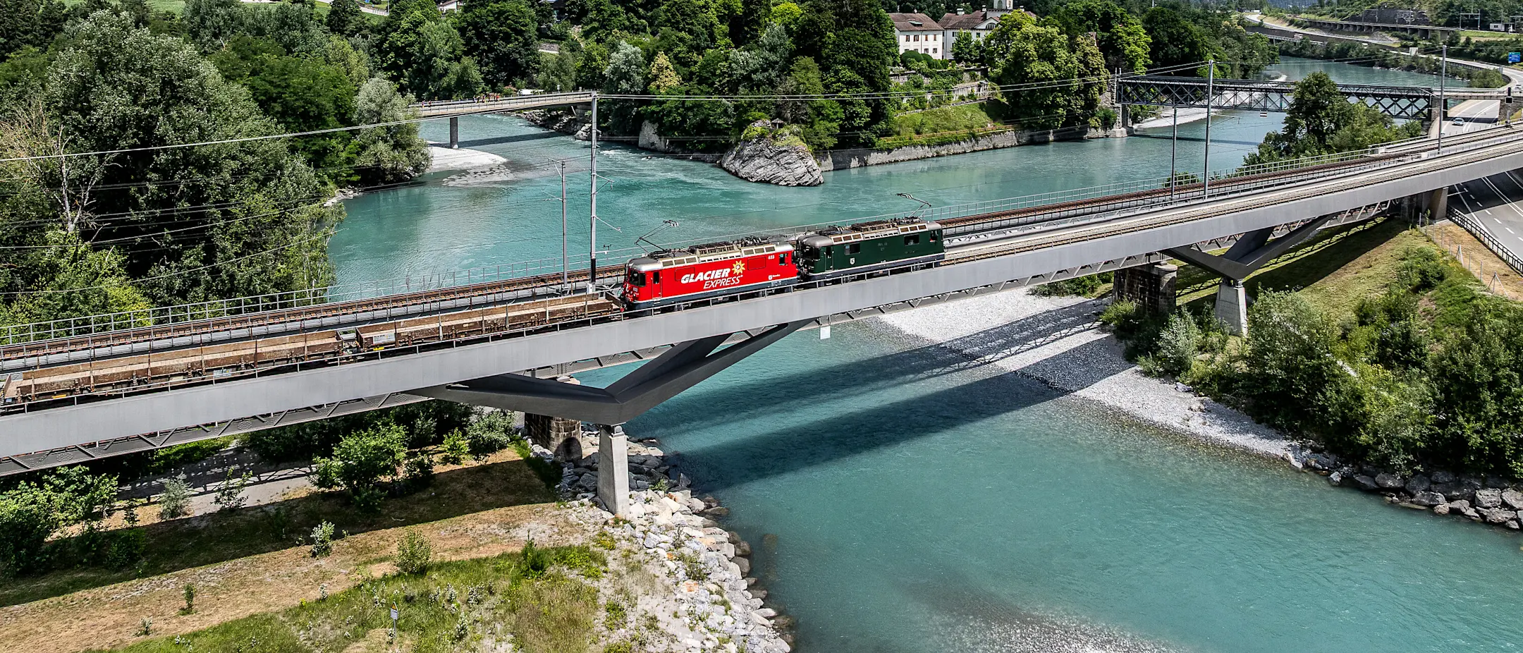 Die Loks Ge 4/4 II 623 im Design des Glacier Express und Ge 4/4 II 611 in grün auf der Hinterrheinbrücke in Reichenau-Tamins.