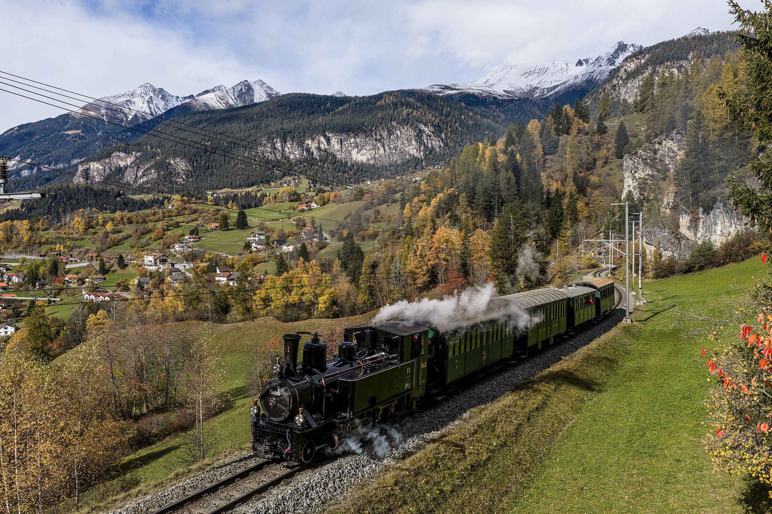 Die Dampflokomotive Heidi fährt durch die herbstliche Landschaft im Albulatal.