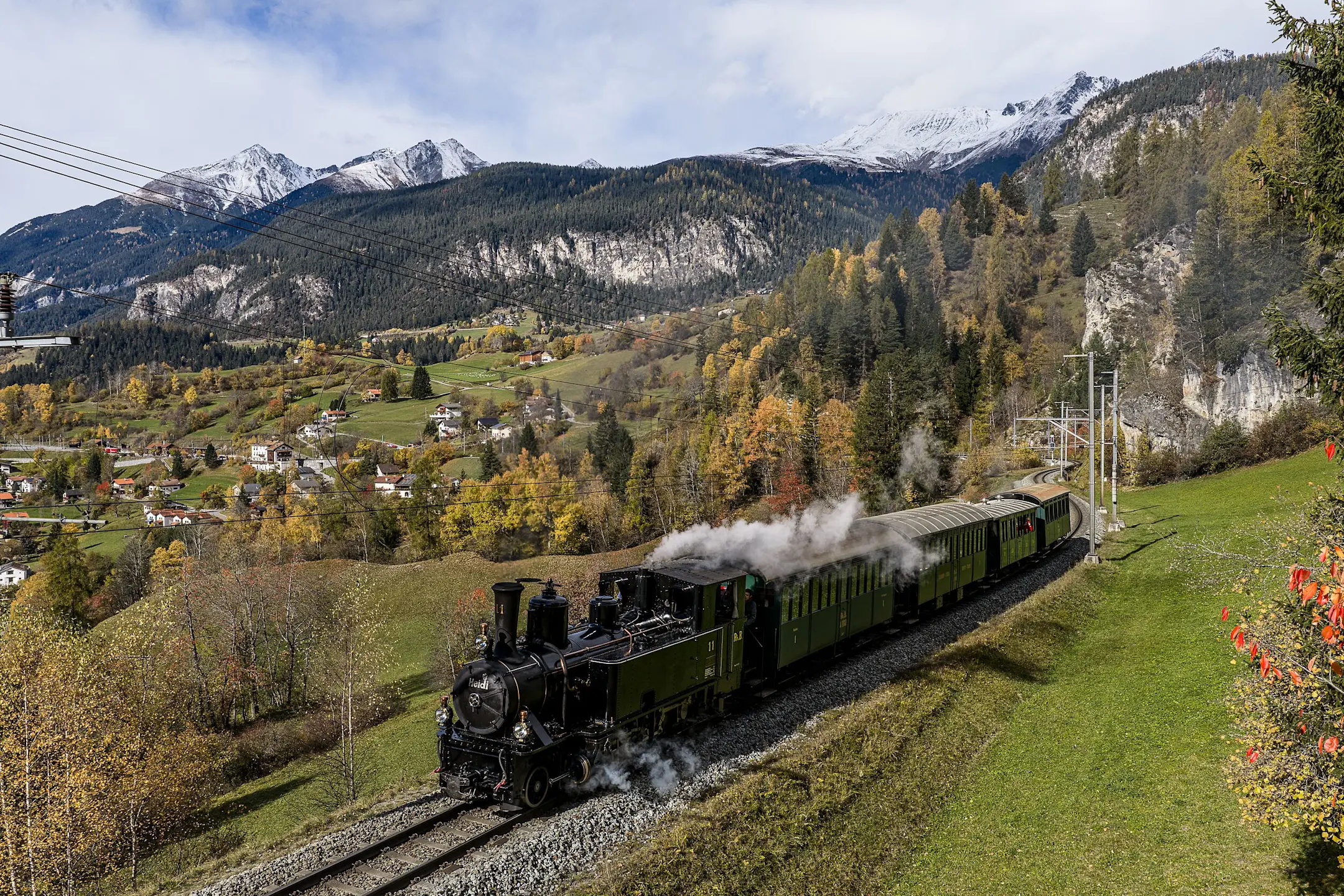 Die Dampflokomotive Heidi fährt durch die herbstliche Landschaft im Albulatal.