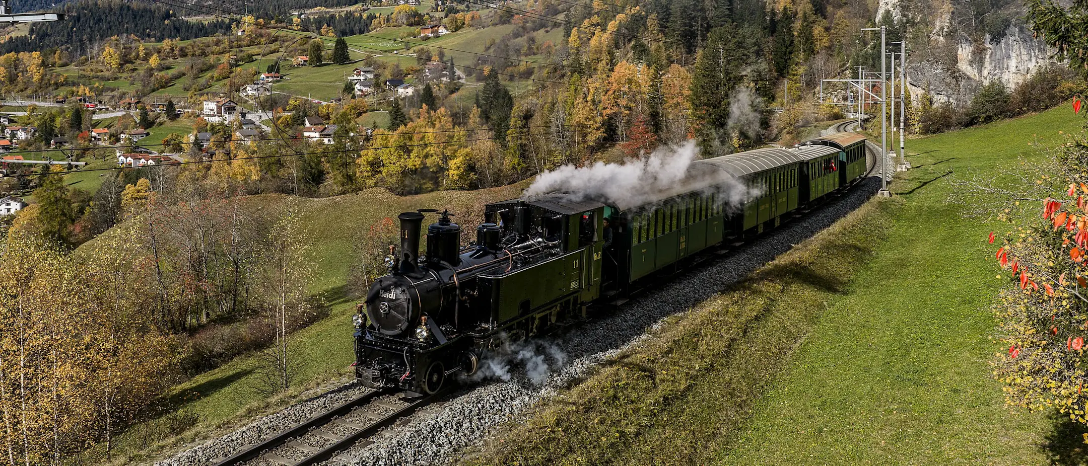 Die Dampflokomotive Heidi fährt durch die herbstliche Landschaft im Albulatal.