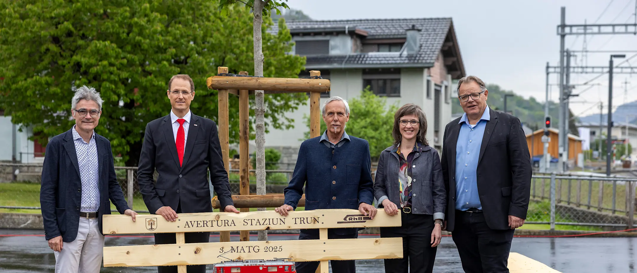 Mario Cavigelli, Renato Fasciati, Dumeni Tomaschett, Carmelia Maissen und Christian Florin  stehen hinter einer Sitzbank.