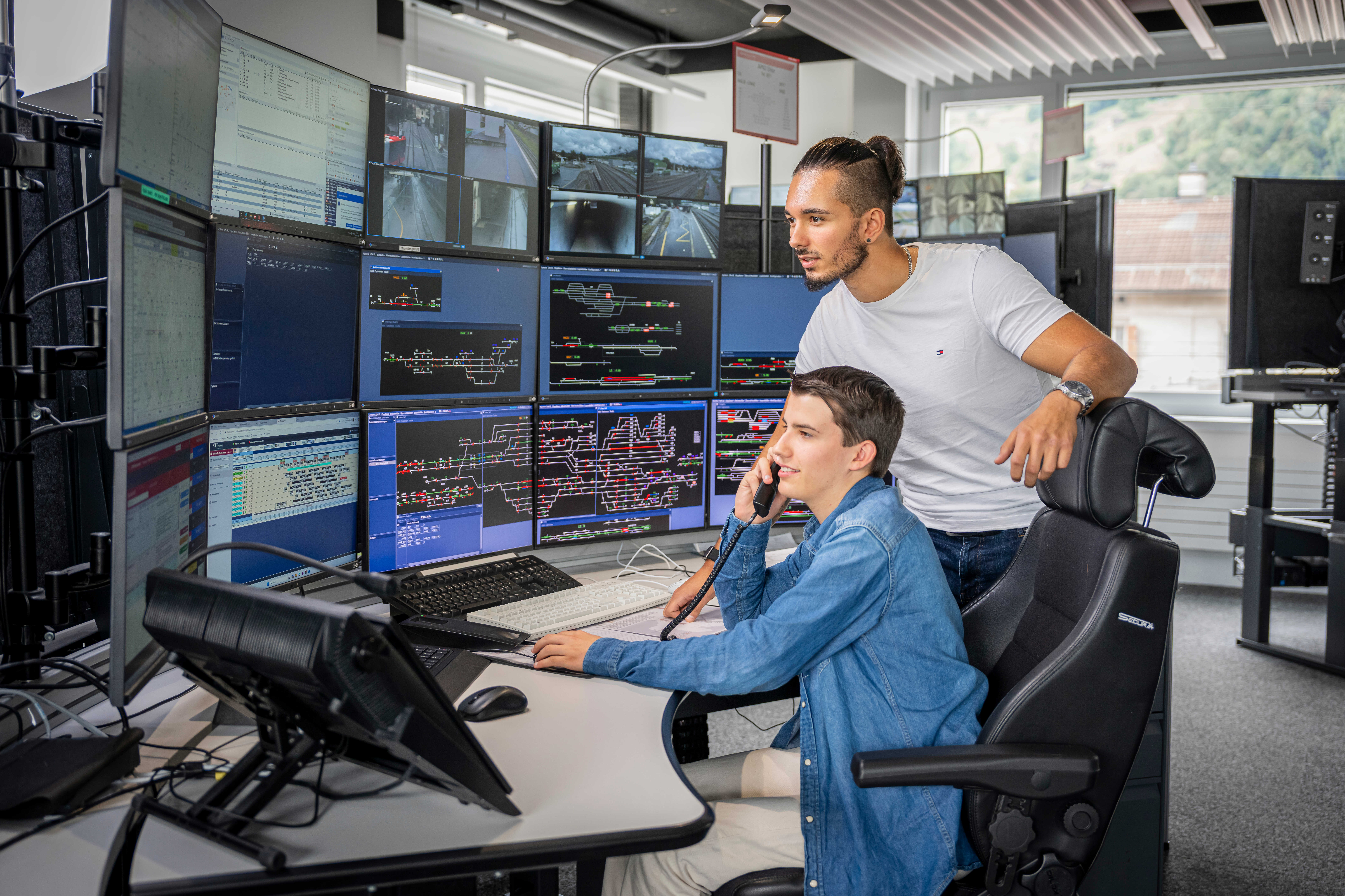 Zwei Fahrdienstleiter in der Betriebszentrale bei der Arbeit