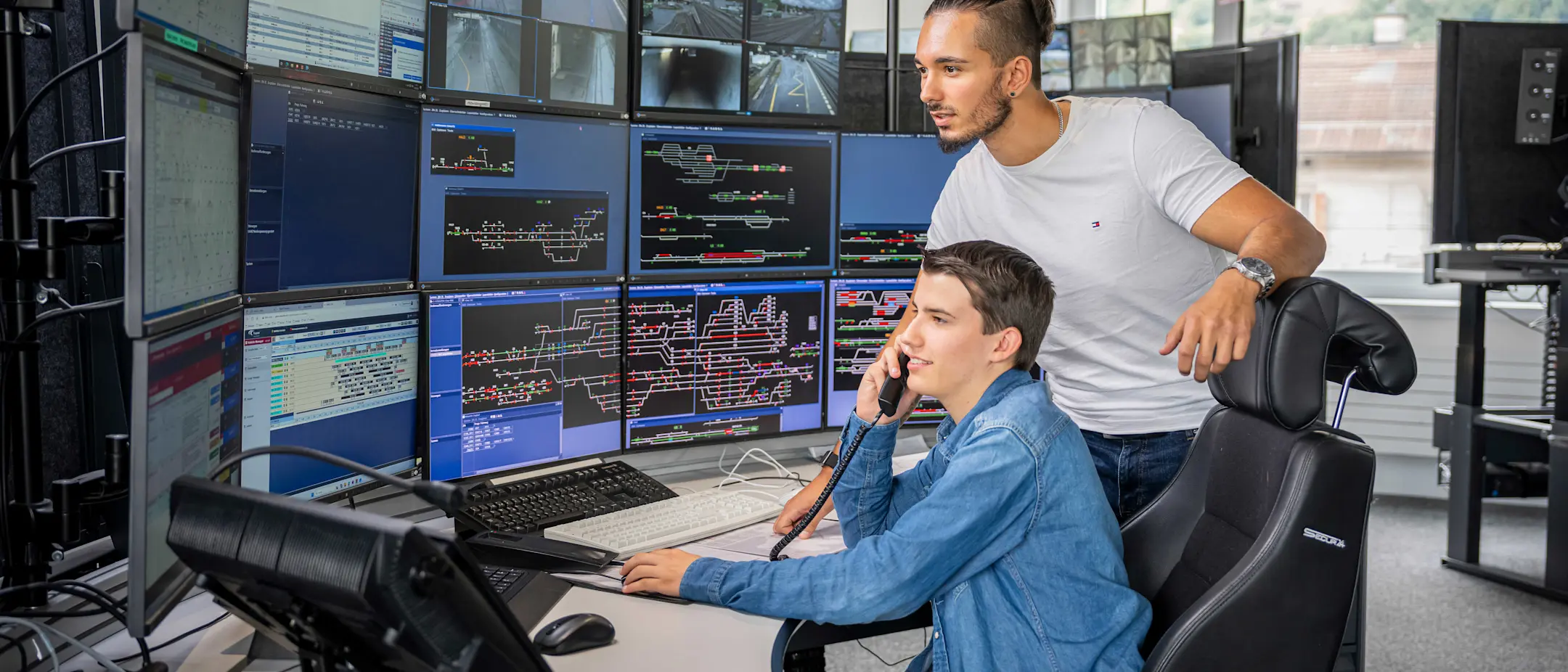 Zwei Fahrdienstleiter in der Betriebszentrale bei der Arbeit