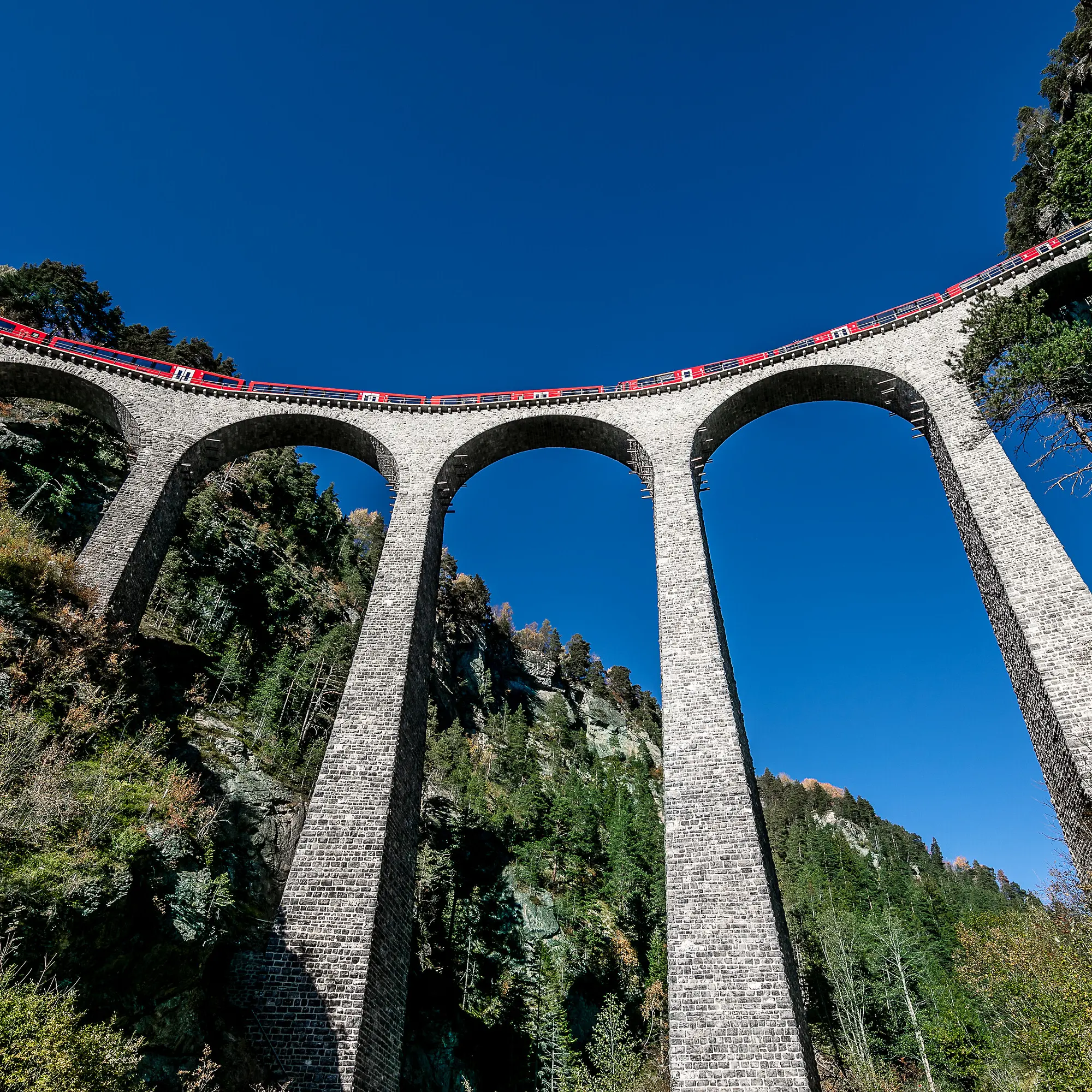Blick von unten hinauf zum Alvra-Gliederzug, der den Landwasserviadukt überquert.