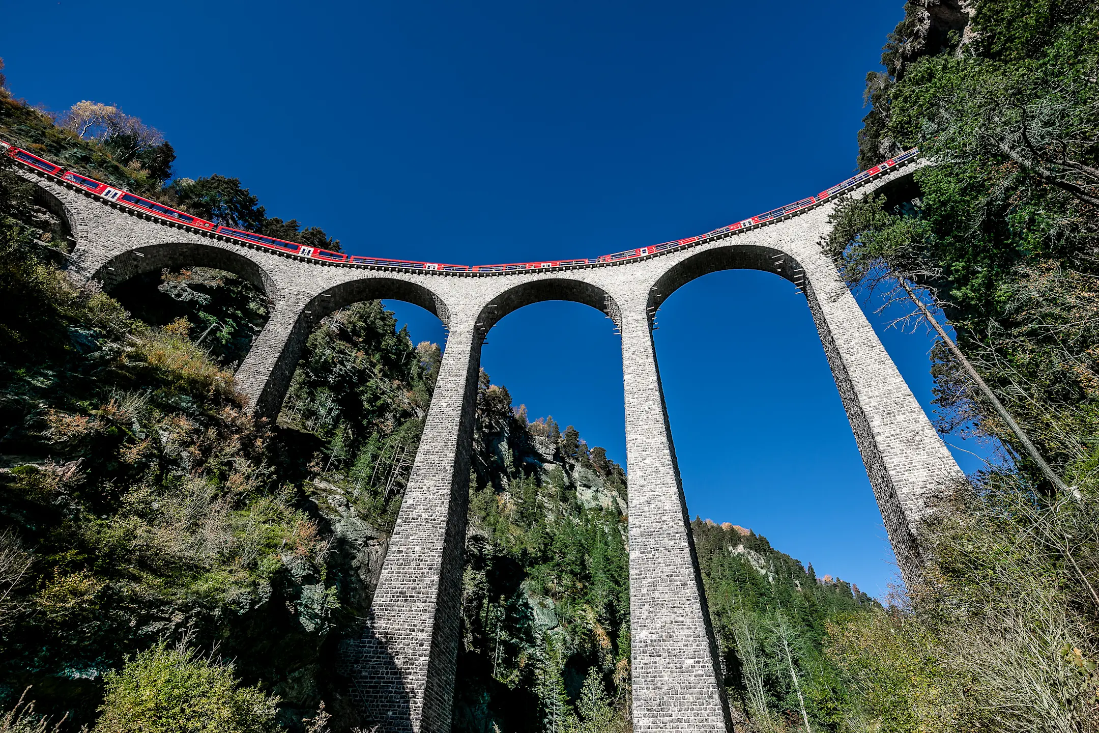 Blick von unten hinauf zum Alvra-Gliederzug, der den Landwasserviadukt überquert.